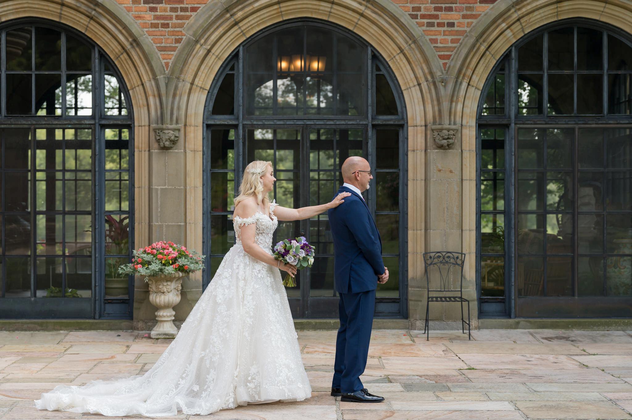 A bride and groom share a first look at Meadow Brook Hall on their wedding day.  