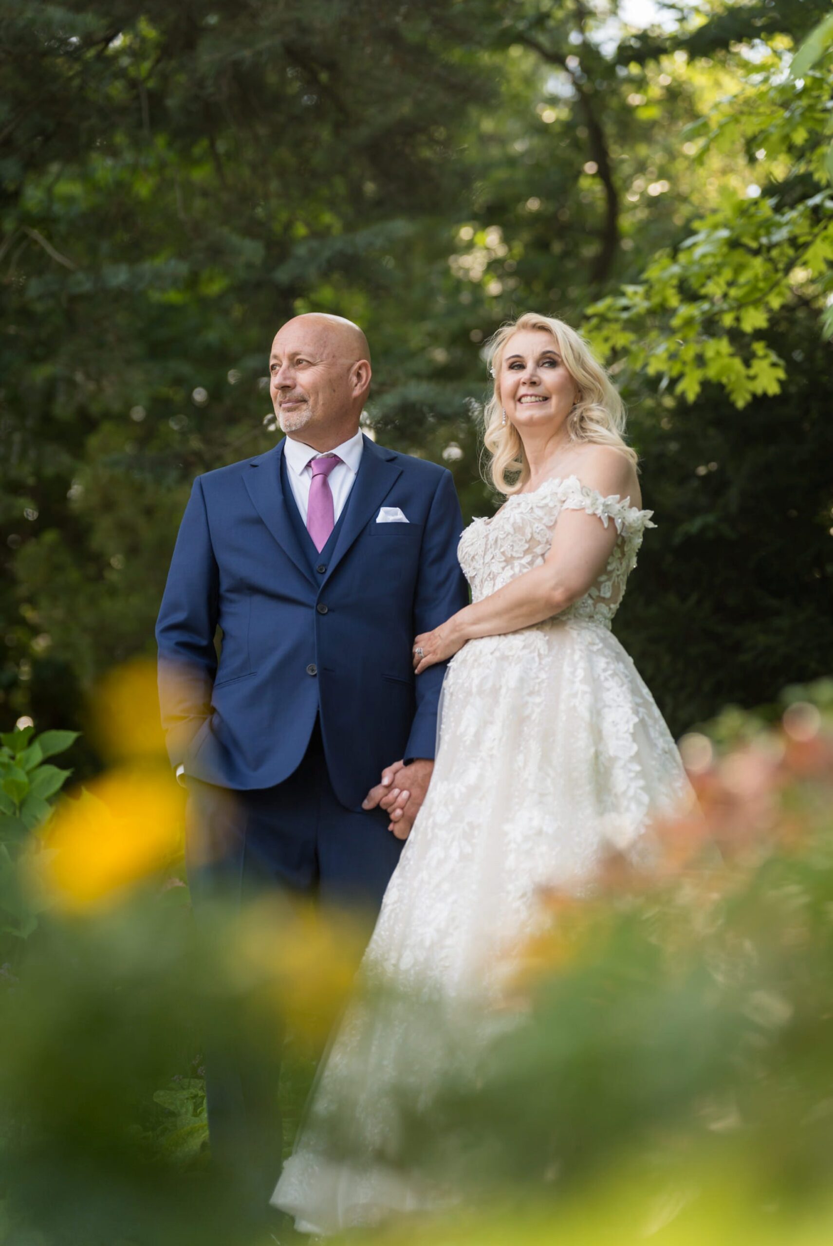 A bride and groom pose in the gardens of Meadow Brook Hall on their wedding day. 