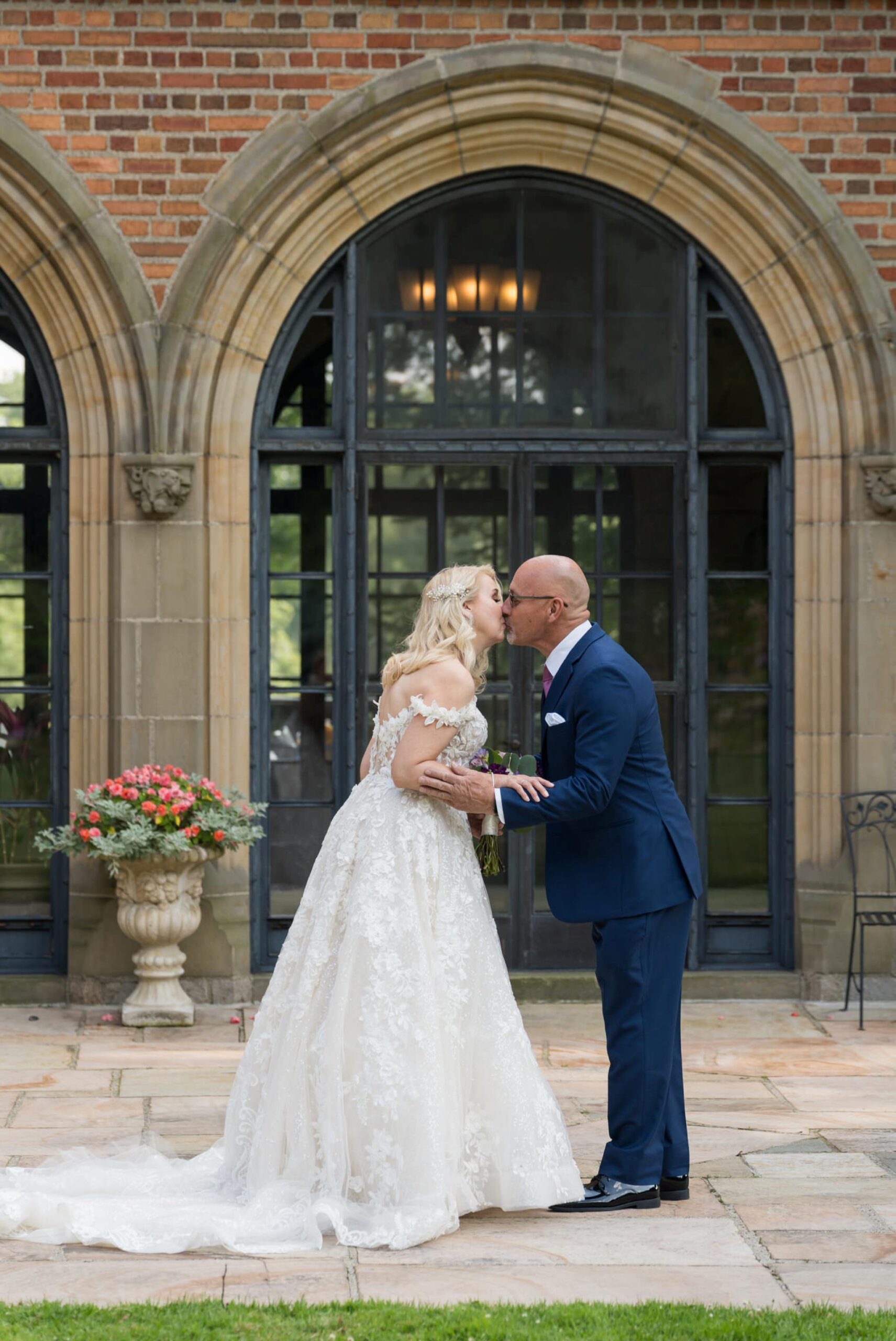 A groom kisses his bride during a first look at Meadow Brook Hall.  