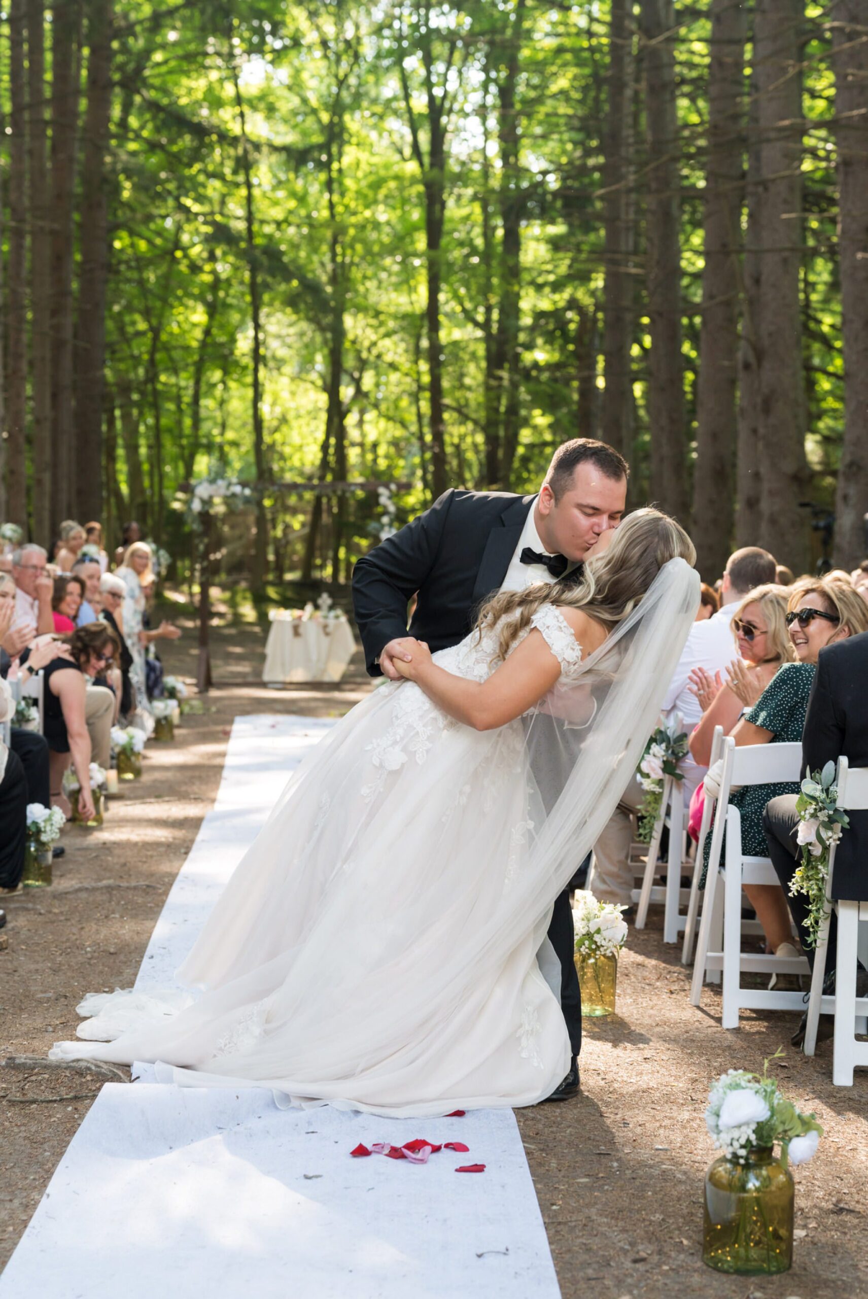 The bride and groom kiss at the end of the aisle at their Stony Creek wedding in The Pines.  