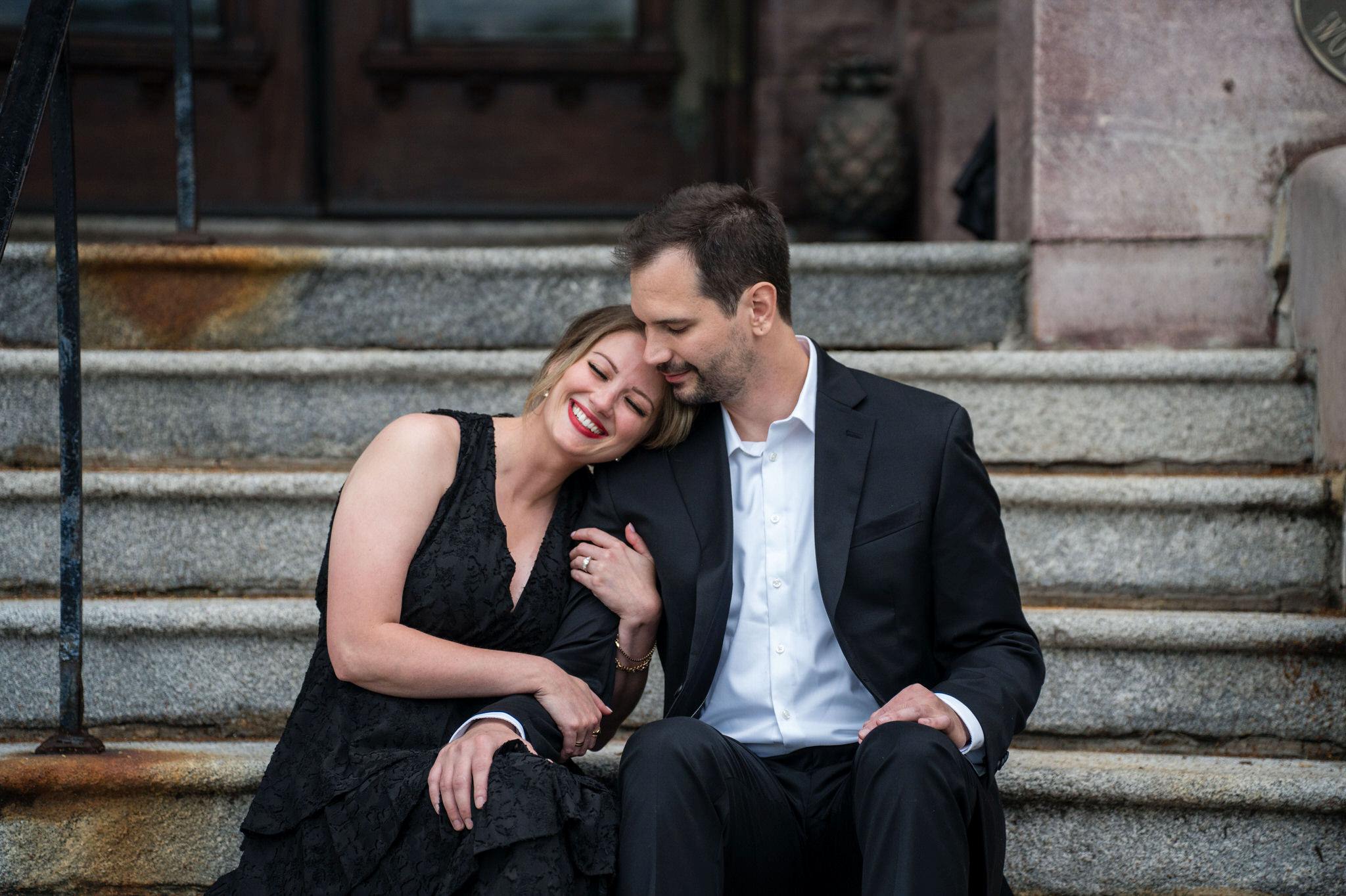 Sitting on the steps of the entrance, a couple laughs after their Whitney Proposal in Detroit.  