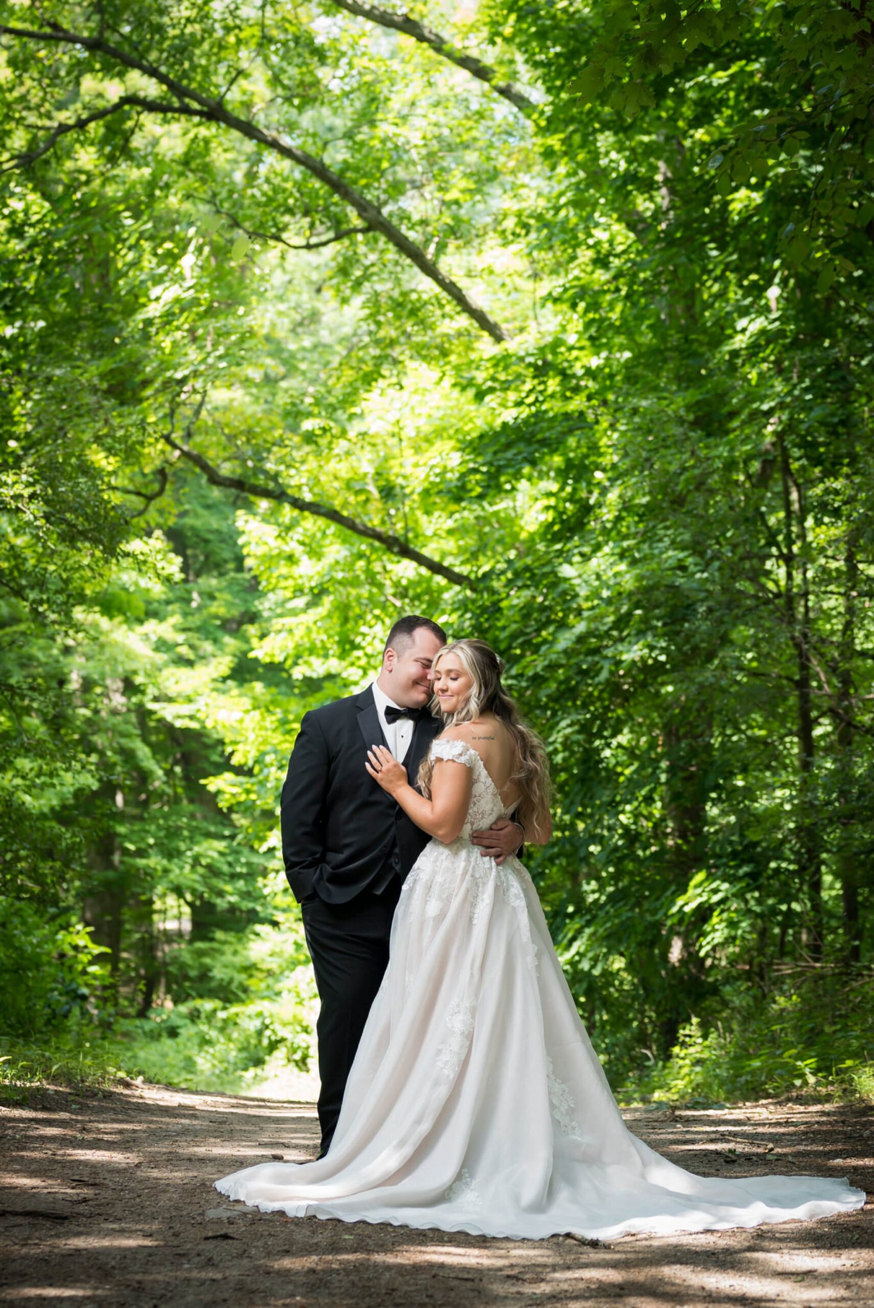 A bride and groom pose on a walking trail at their Stony Creek wedding. 