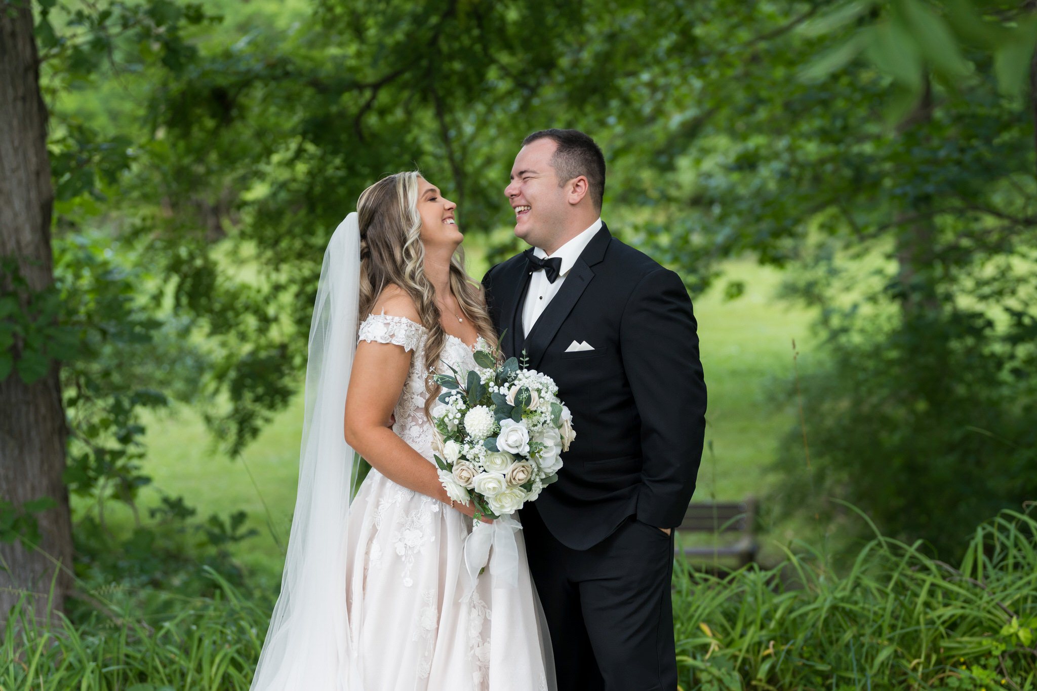 A bride and groom laugh during their wedding at Van Hoosen in Rochester, MI. 