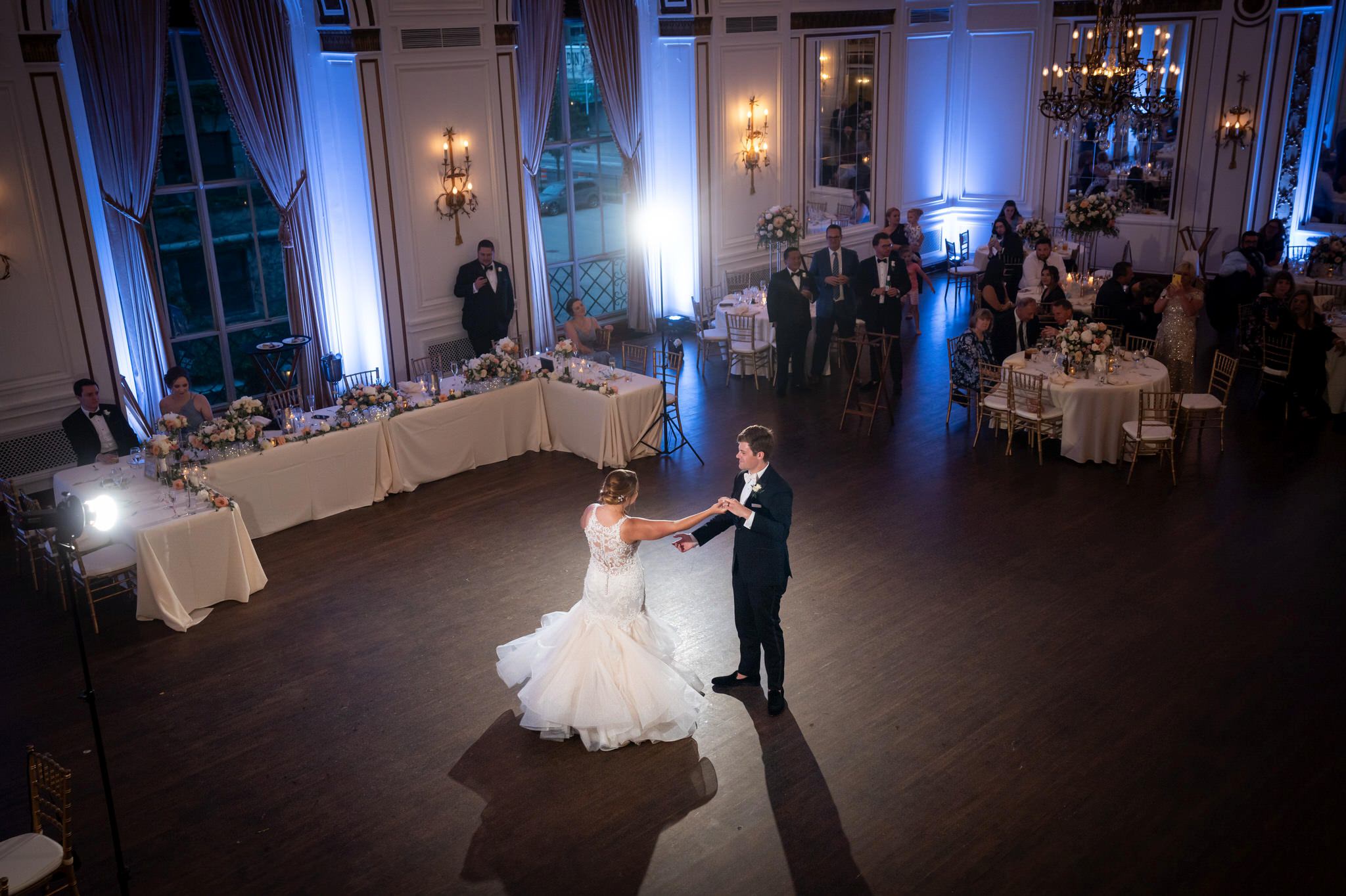A bride and groom dance in a colorful ballroom at Forbes Hospitality Colony Club.
