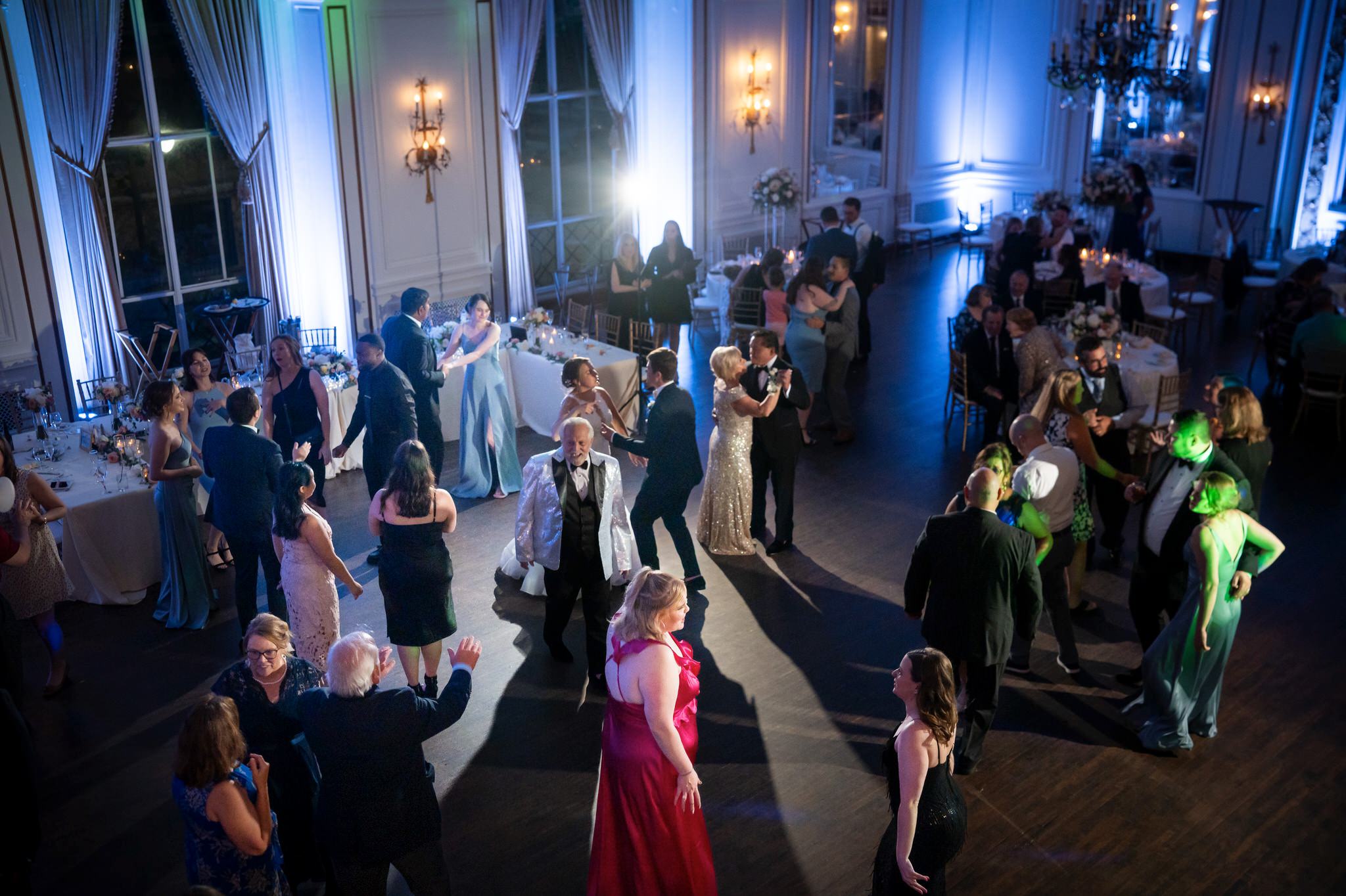 Guests dance in a colorful ballroom at Forbes Hospitality Colony Club. 