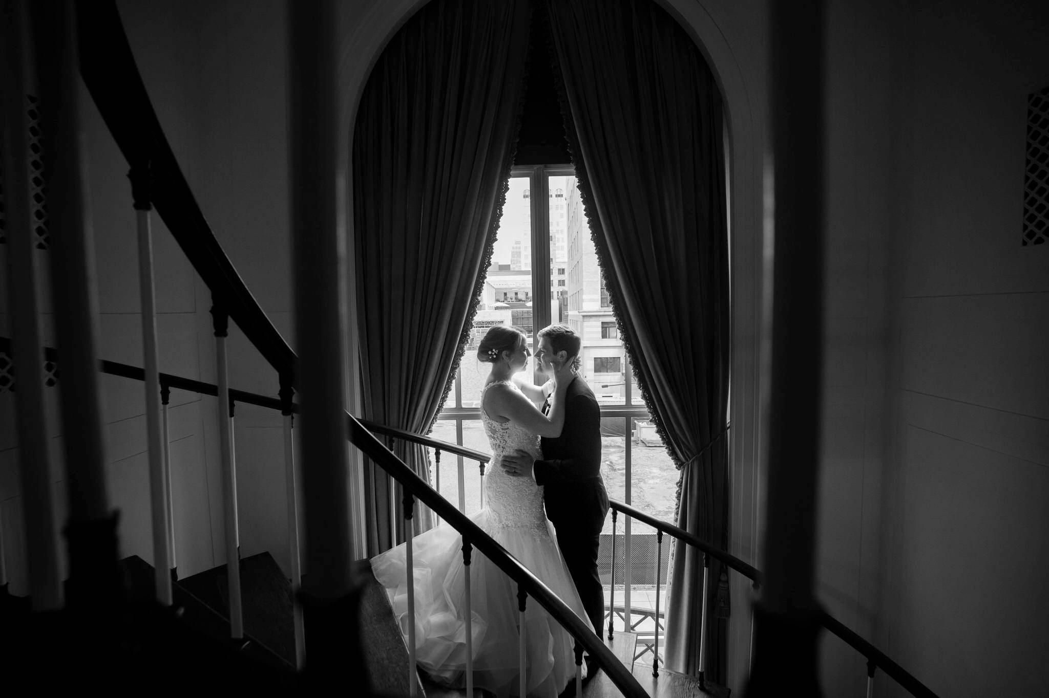 A bride and groom embrace in a stairwell at Forbes Hospitality Colony Club. 