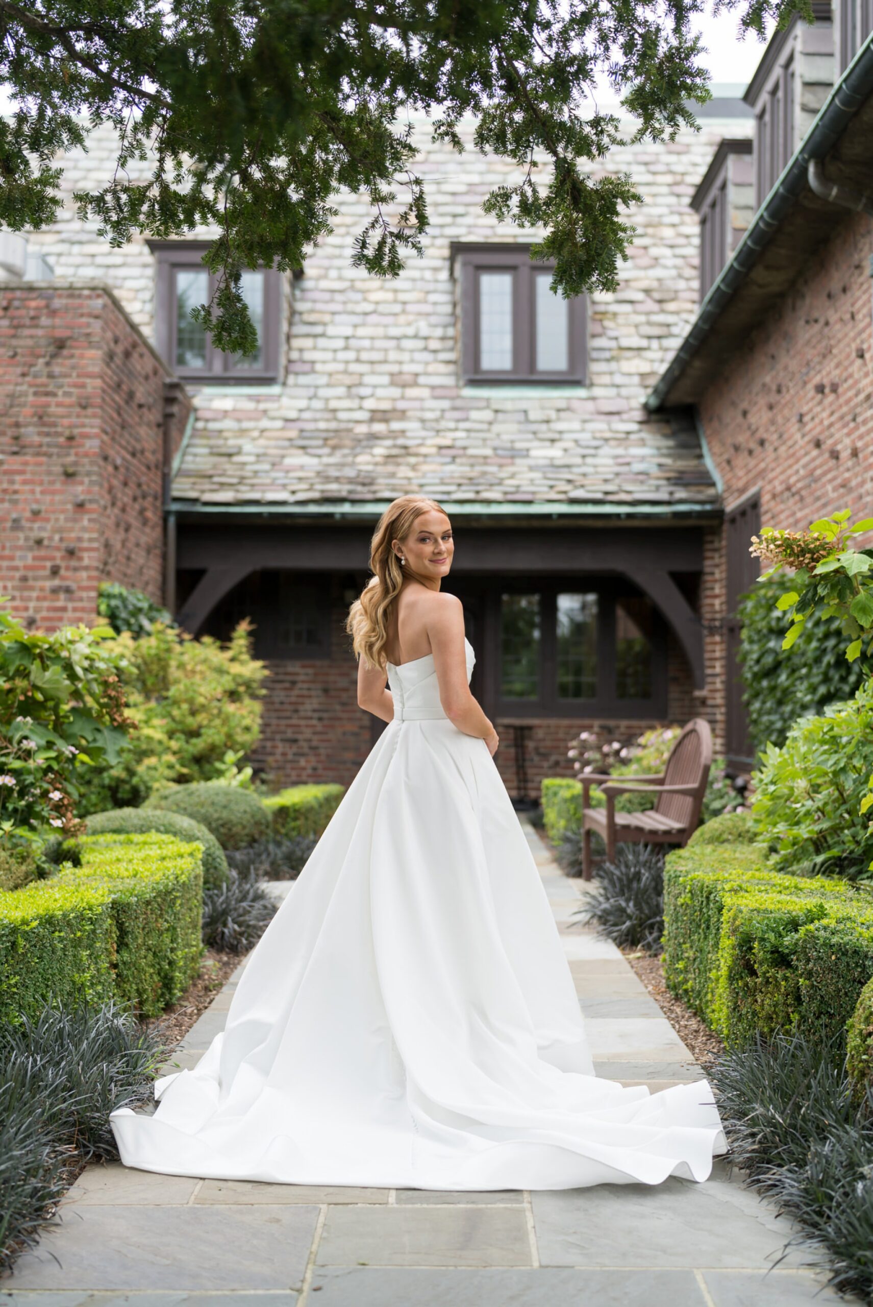 A bride shows off her dress prior to her Country Club of Detroit wedding.  