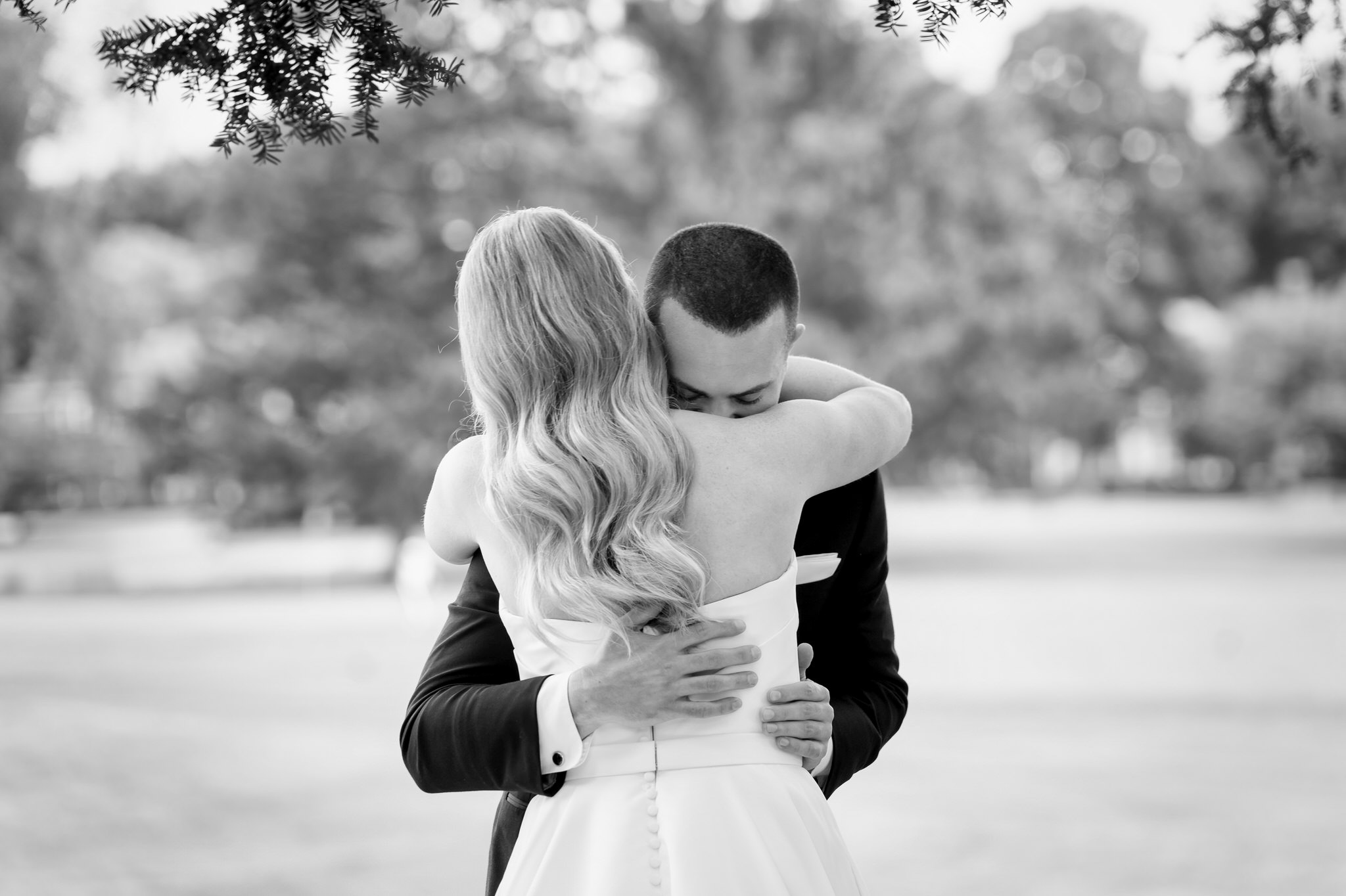 A bride and groom hug on the back patio during their first look of their Country Club of Detroit wedding.  