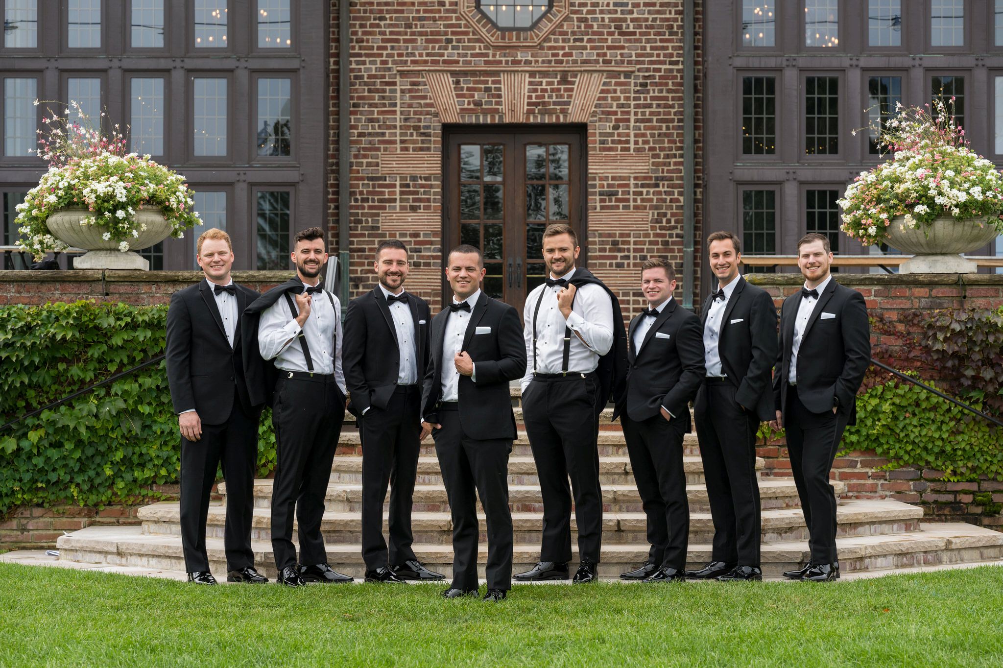 Groomsmen pose the back steps during a Country Club of Detroit wedding.  