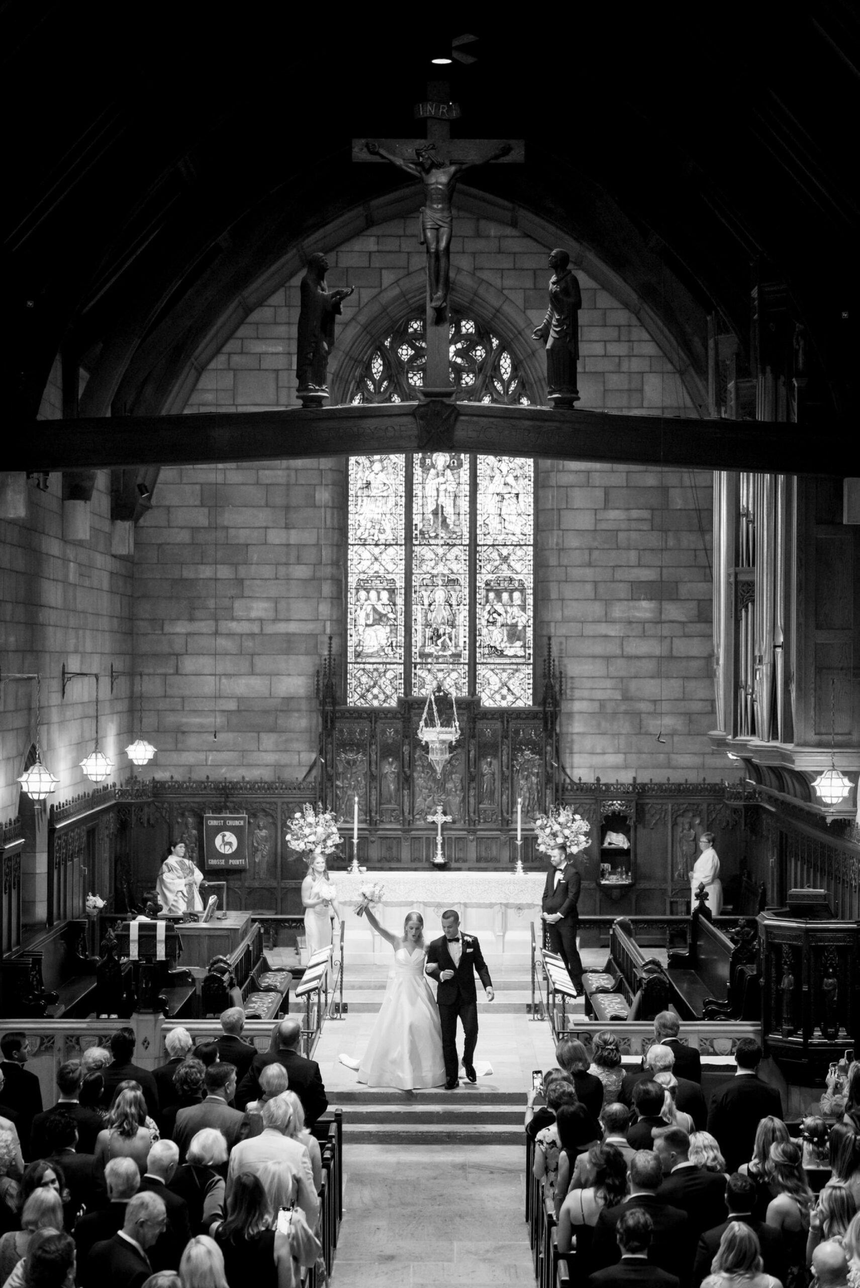 The bride and groom smile, walking down the aisle after their wedding at Christ Church Grosse Pointe.
