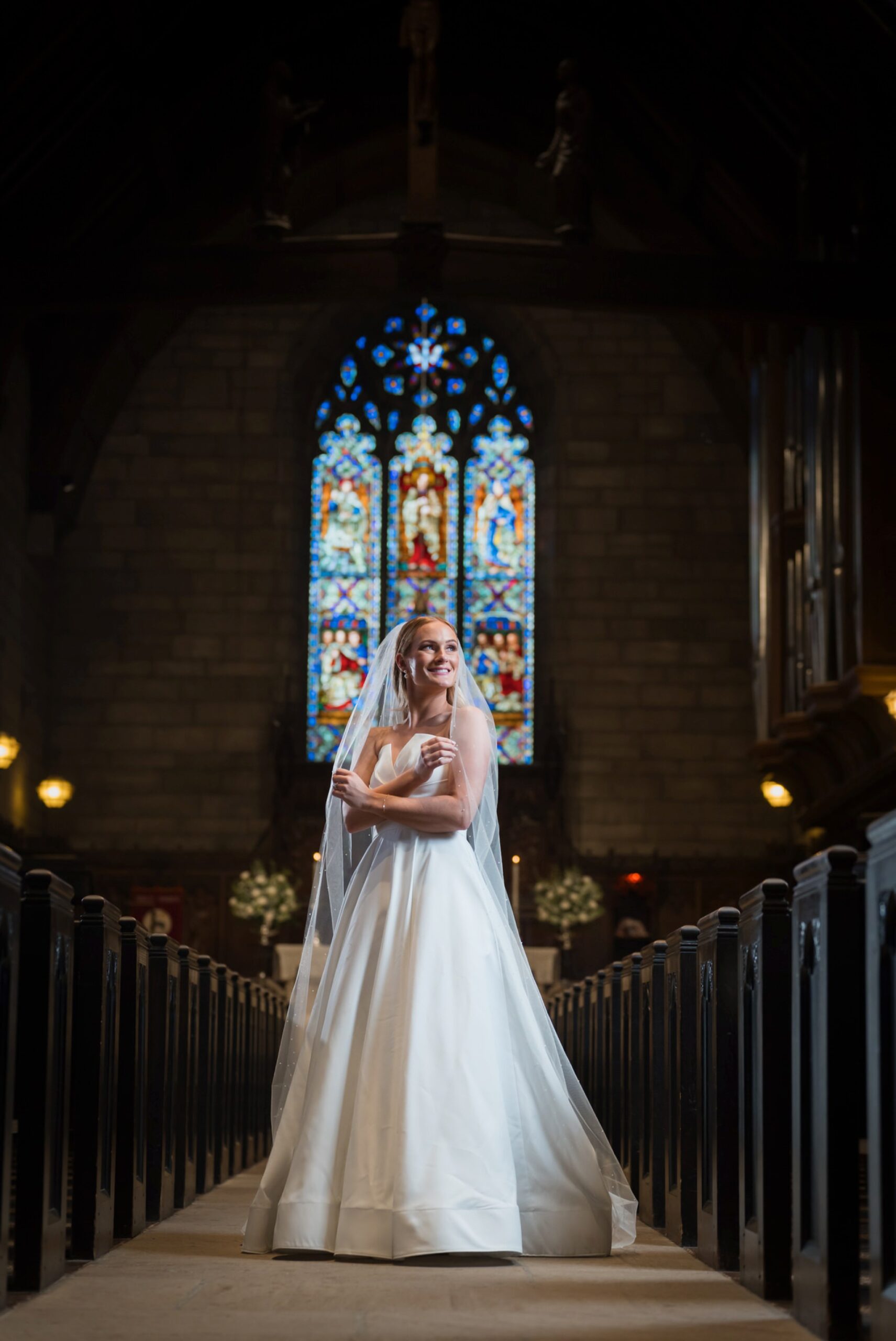 A bride poses in the center aisle after her wedding at Christ Church Grosse Pointe. 