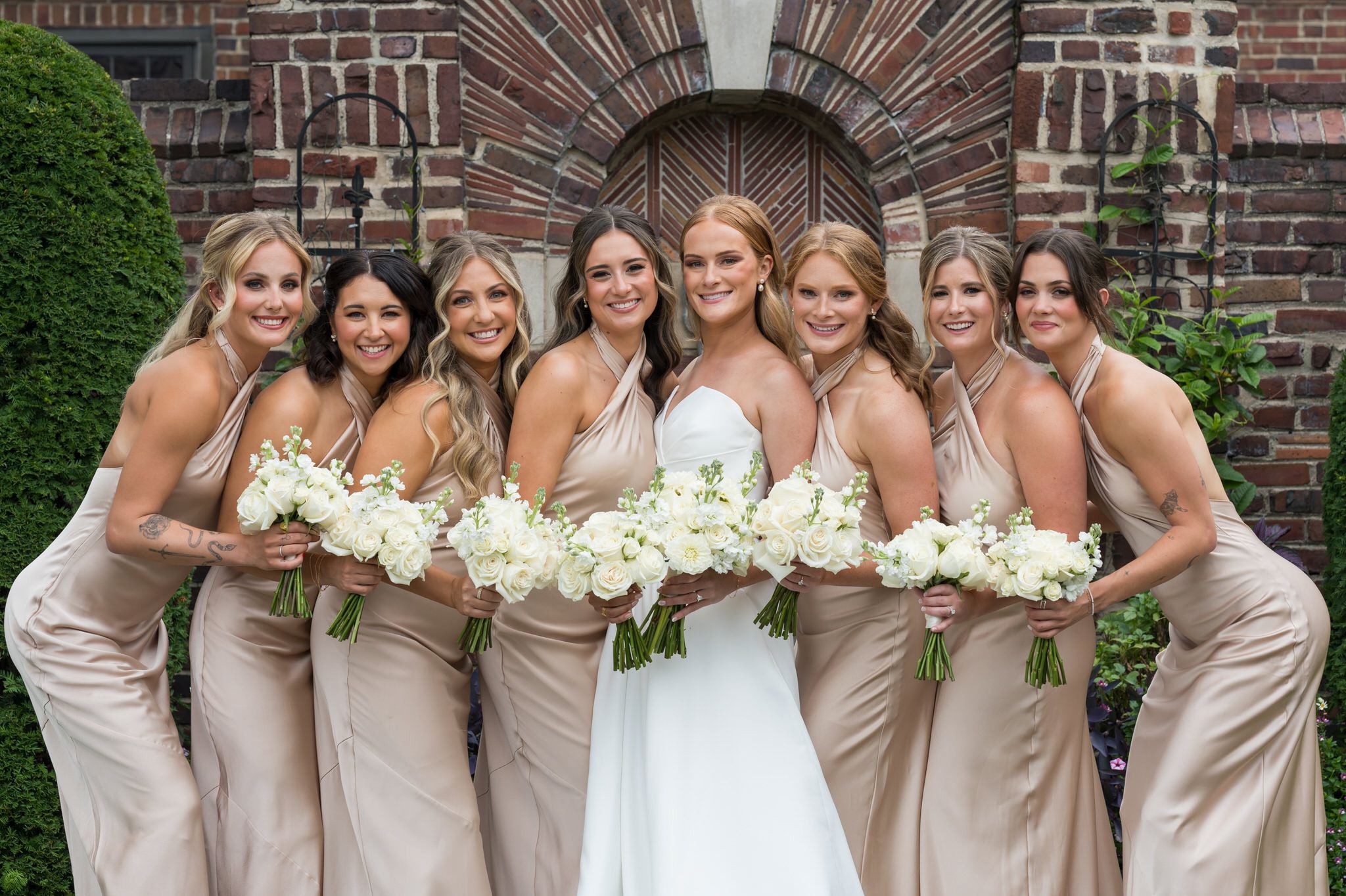 Bridesmaids pose on the front grass of during their Country Club of Detroit wedding. 