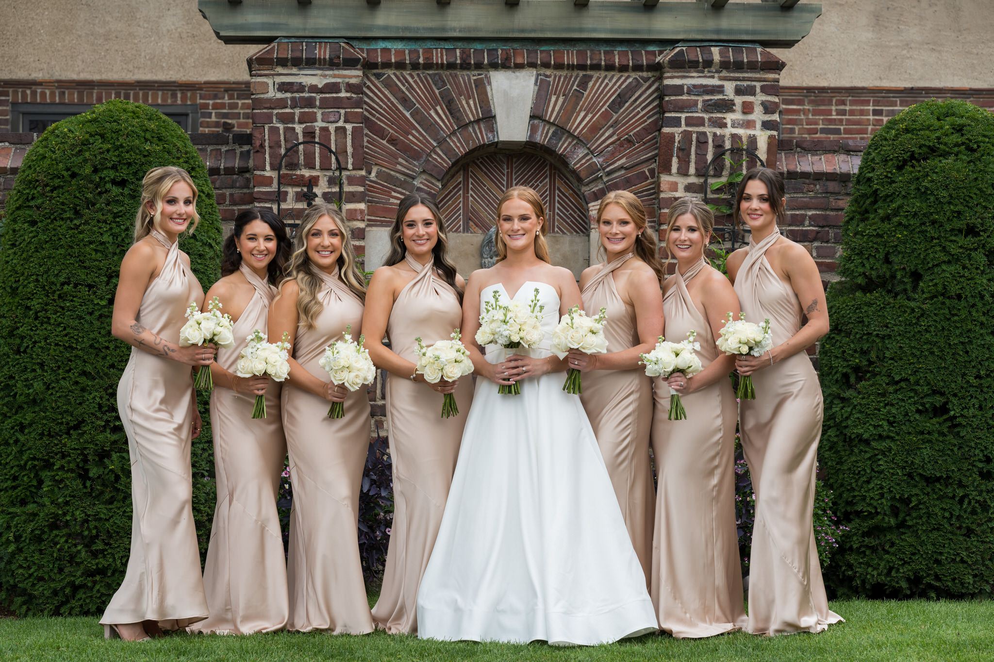 Bridesmaids pose on the front grass of during their Country Club of Detroit wedding. 