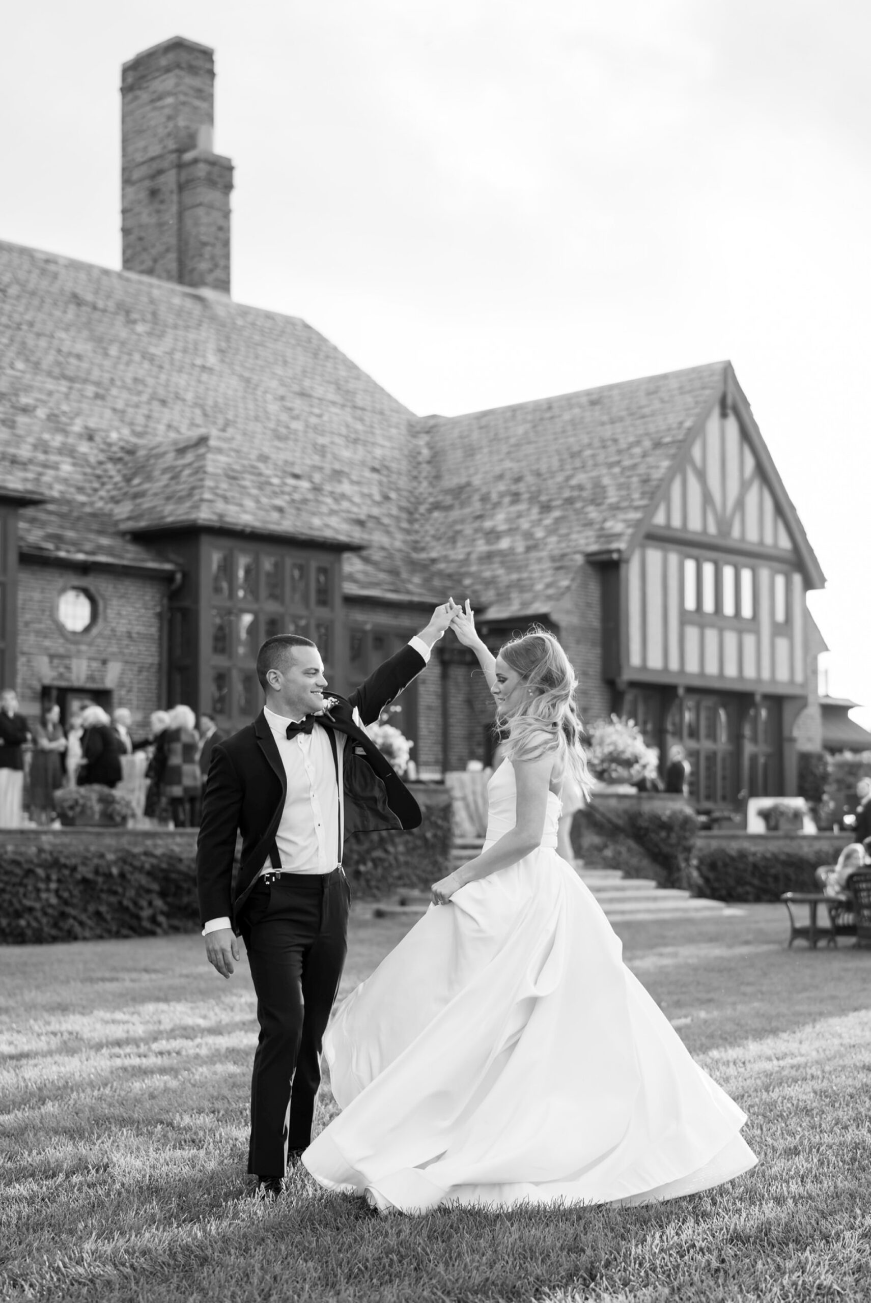 Groom twirls his bride in front of their a Country Club of Detroit wedding reception.
