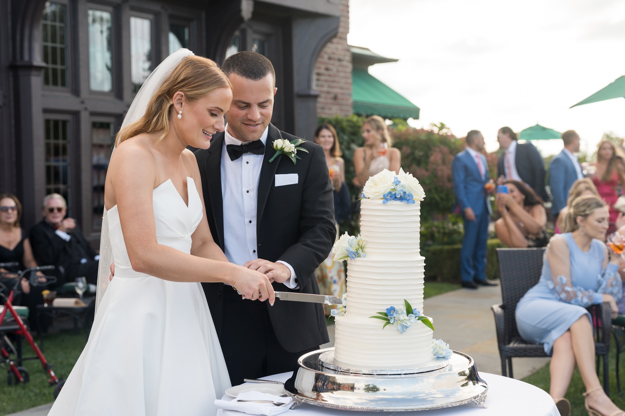 The bride and groom cut cake during their Country Club of Detroit wedding reception.