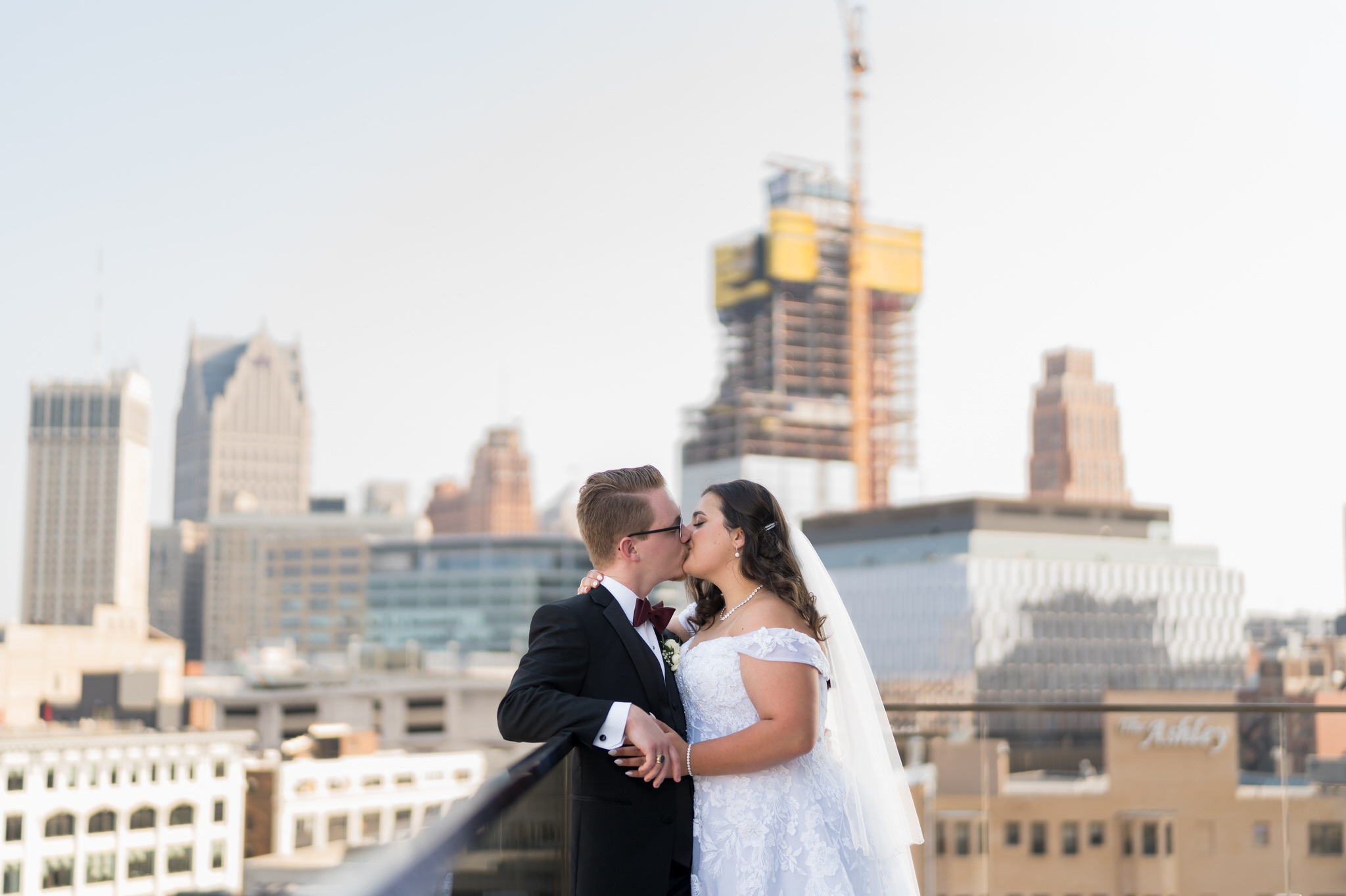 A couple share a kiss on top of the rooftop at their Detroit Athletic Club wedding.  