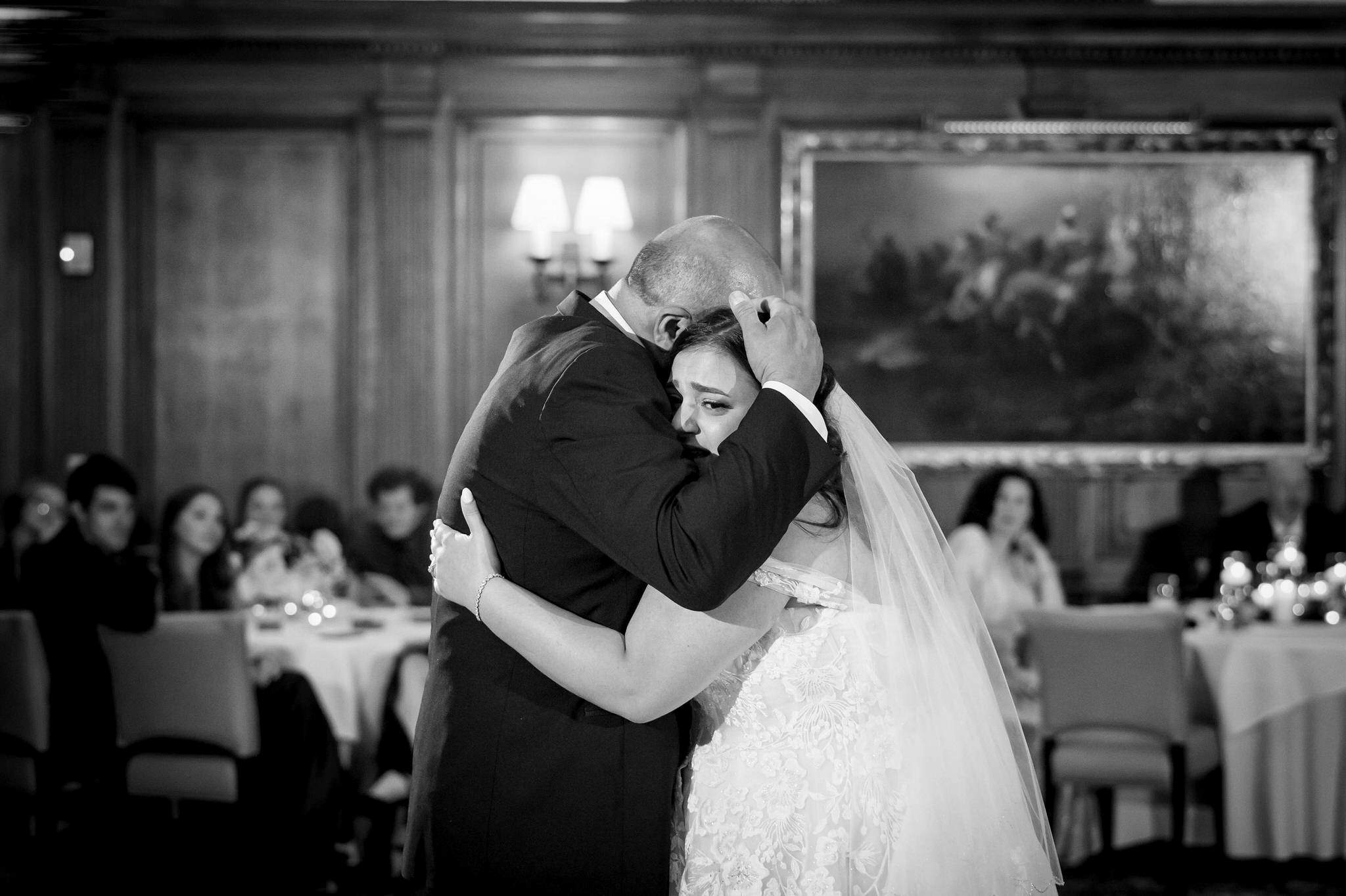 The father of the bride hugs his daughter during their slow dance at a Detroit Athletic Club wedding.