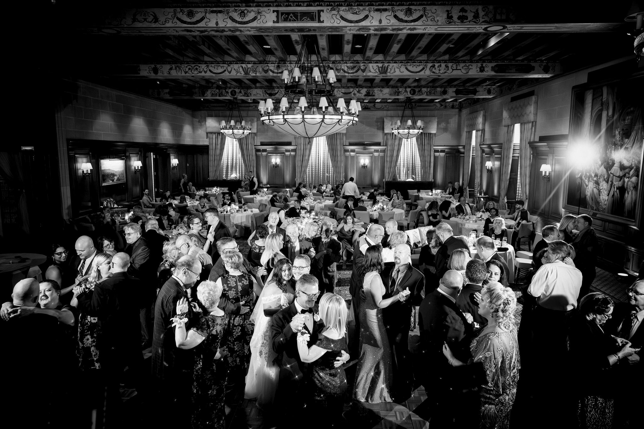 Guests dance in a packed ballroom at a Detroit Athletic Club wedding.