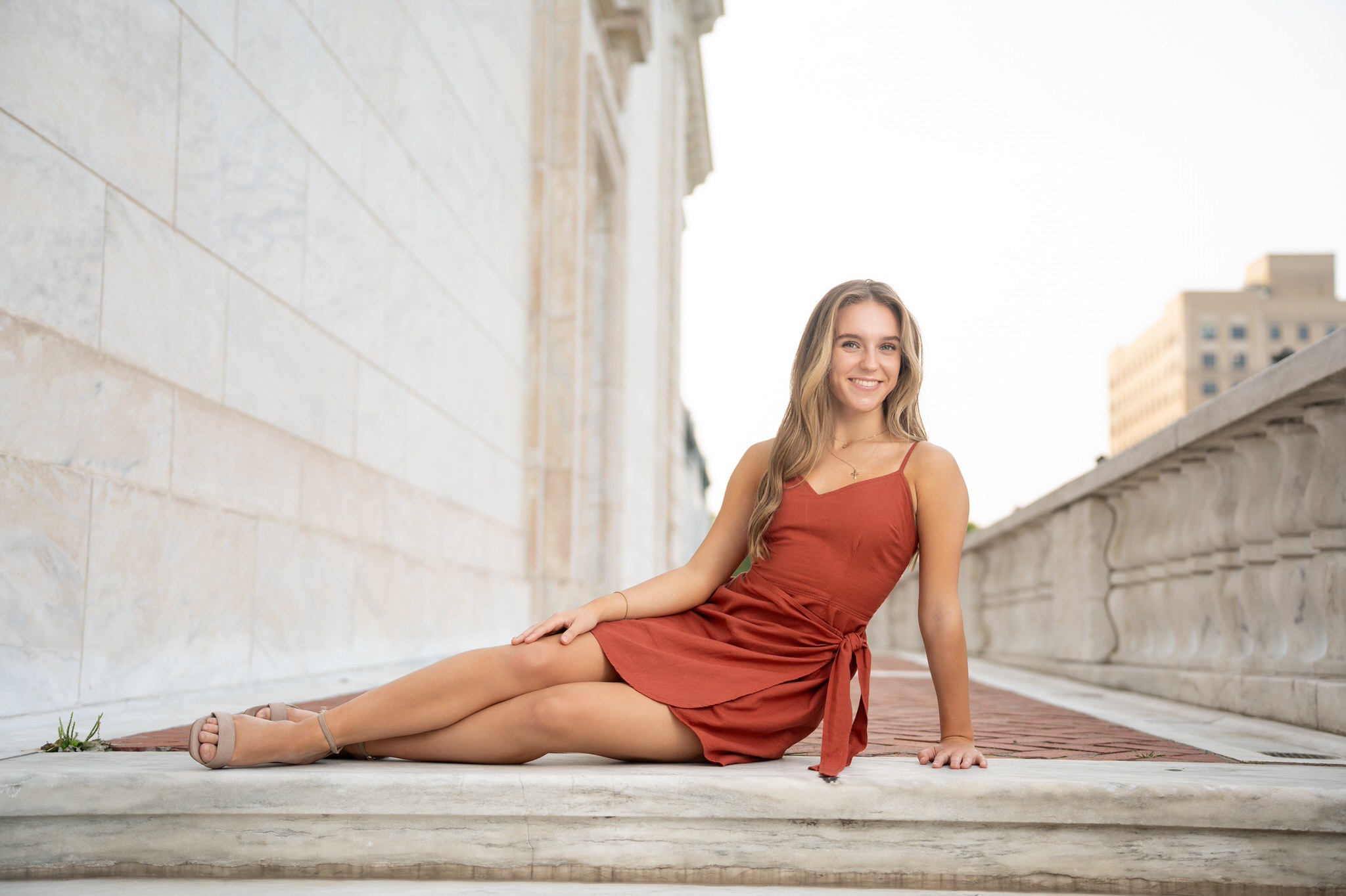 Lounging on the steps, a female teenager poses during her DIA senior photos. 