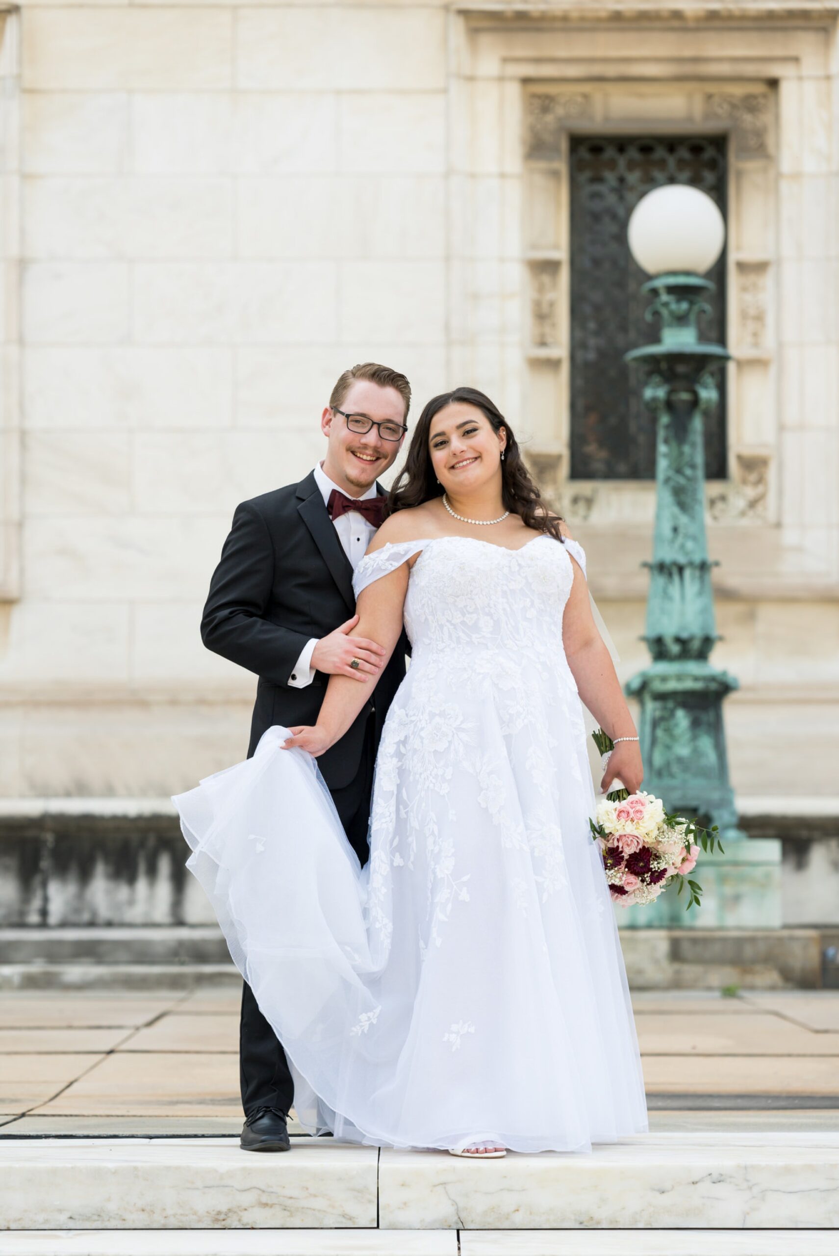 A bride and groom pose on their wedding day at the Detroit Public Library.  