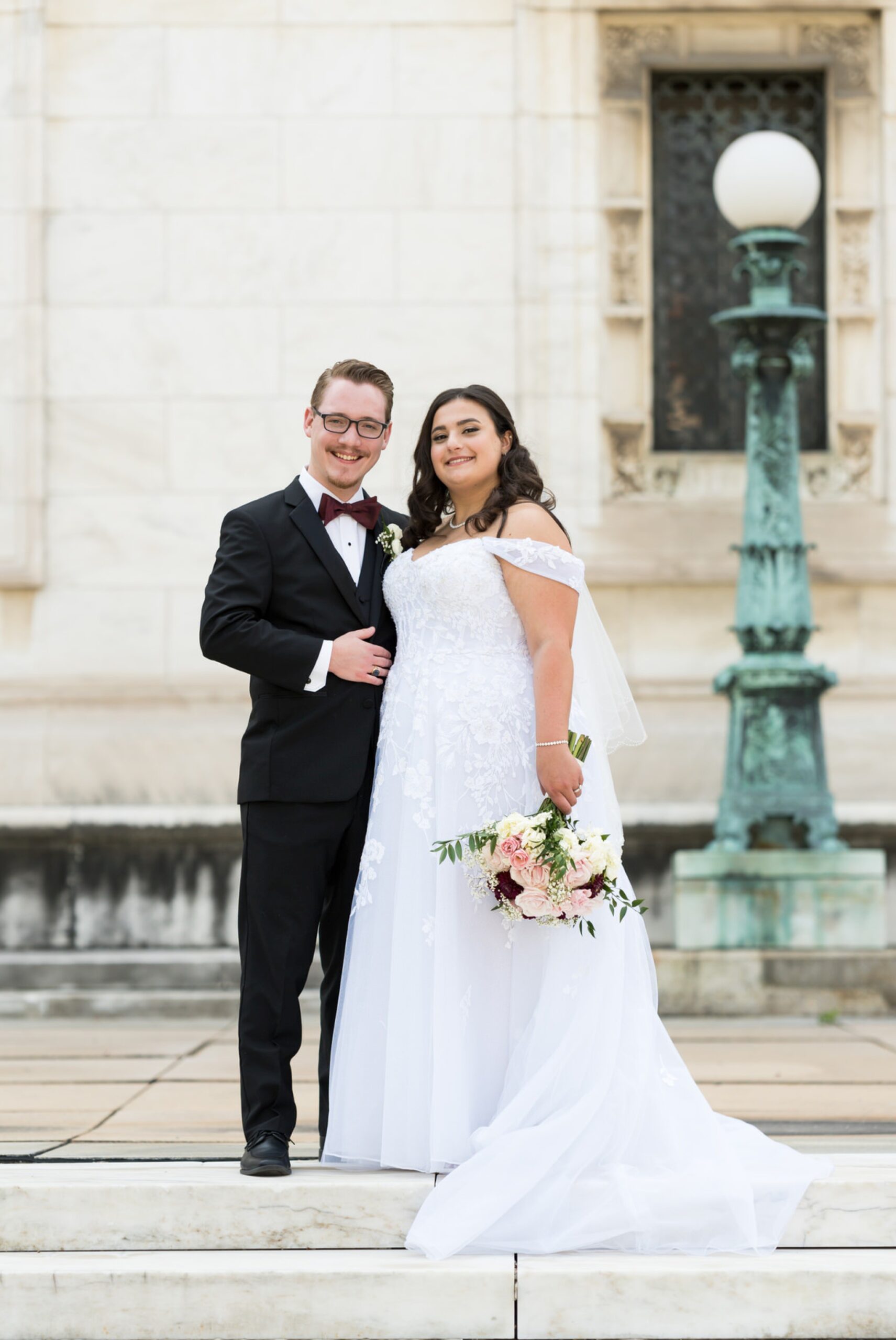 A bride and groom pose on their wedding day at the Detroit Public Library.  