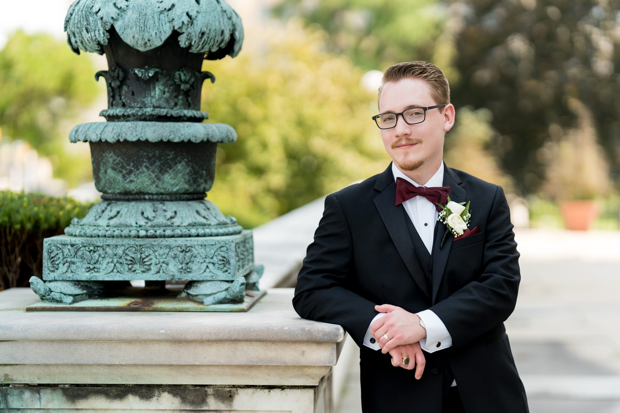 A groom poses on a wall outside of the Detroit Public Library. 