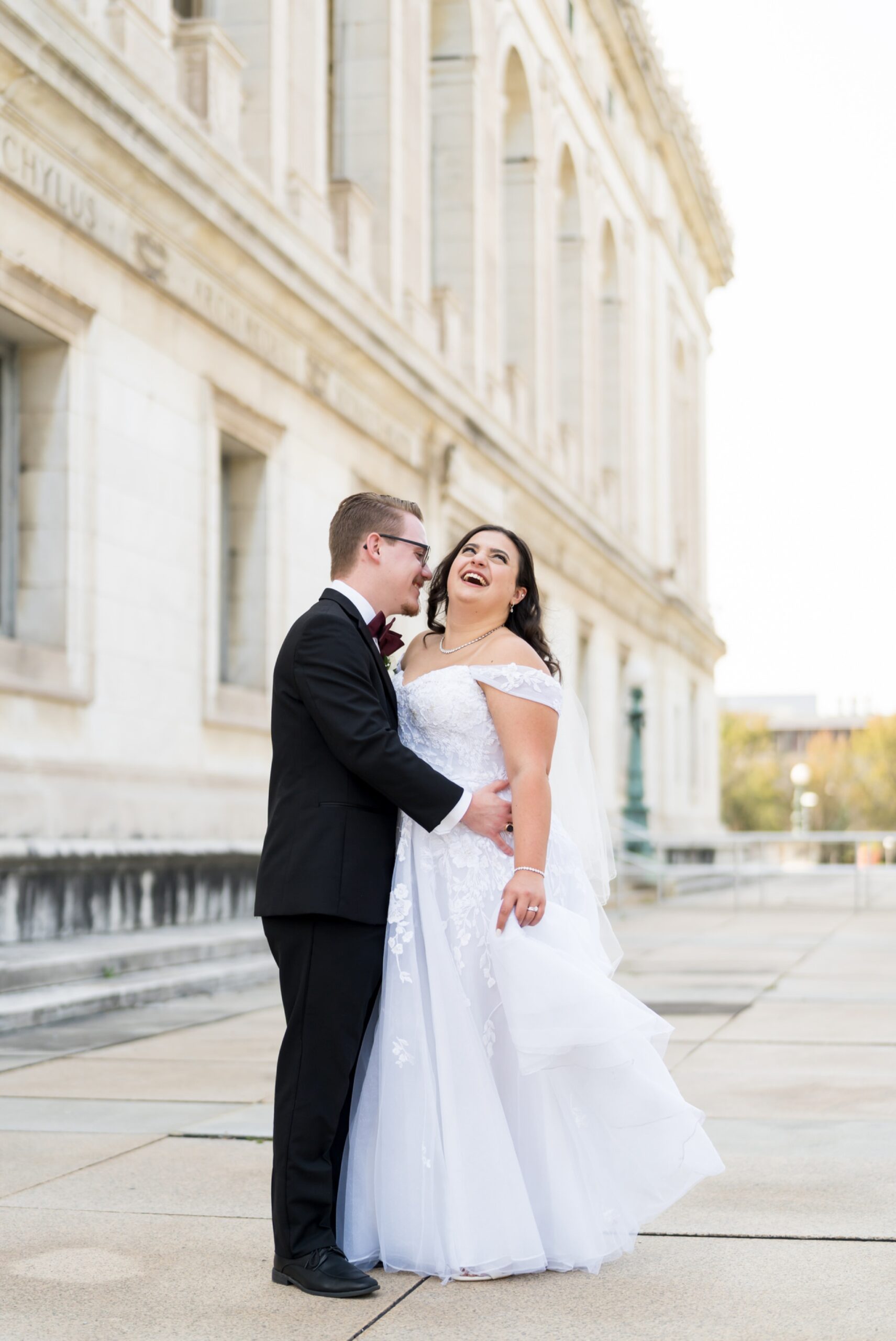 A bride and groom laugh on their wedding day at the Detroit Public Library.  