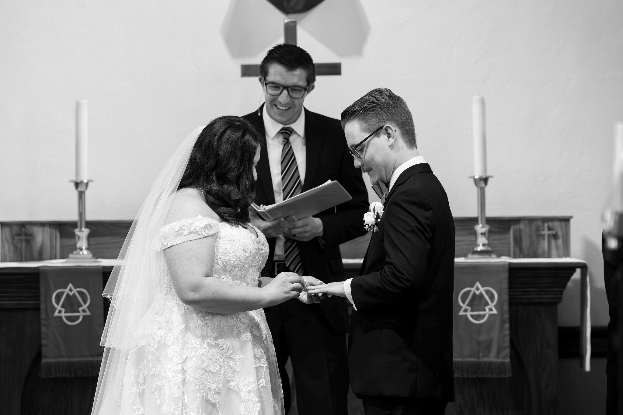 The bride and groom exchange rings at the altar on their wedding day at Immanuel Lutheran Church in Macomb, MI. 
