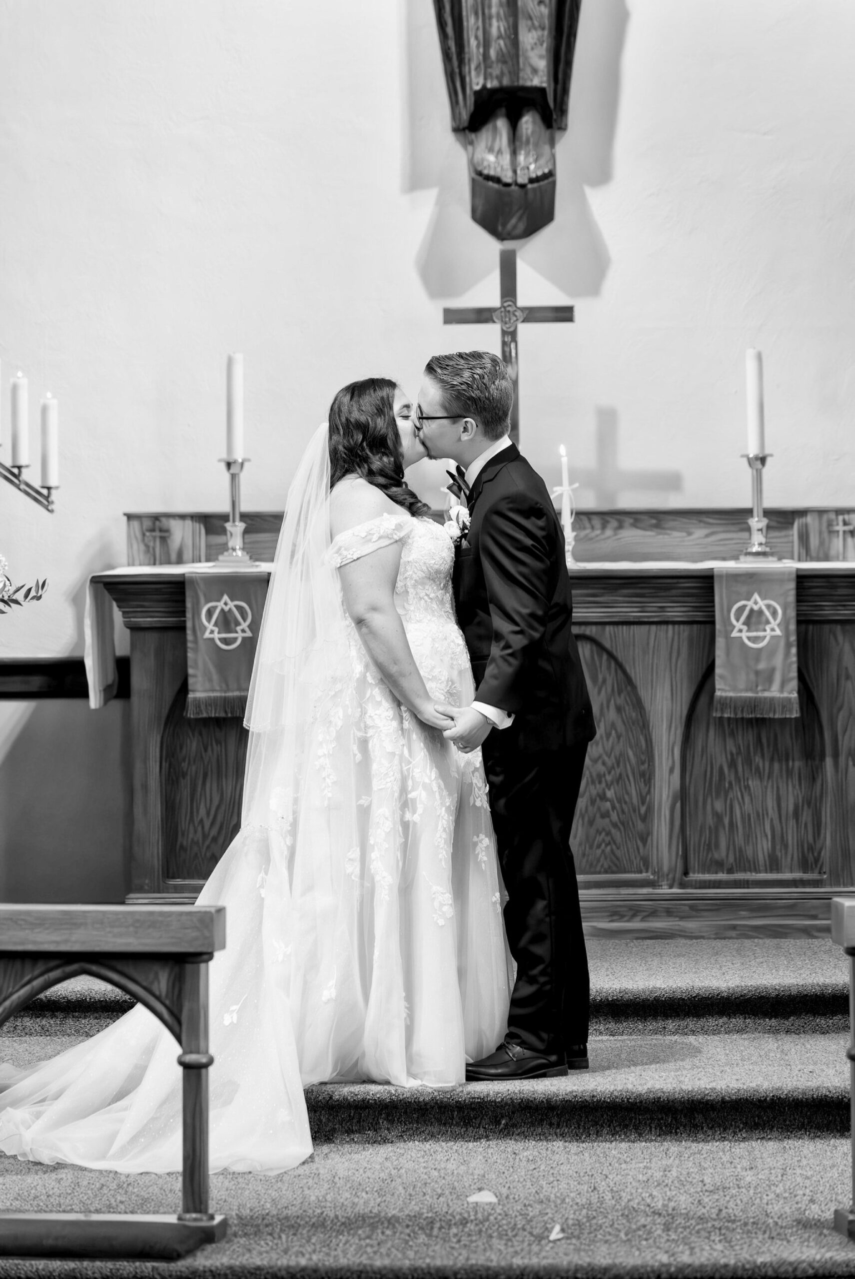 The bride and groom kiss at the altar on their wedding day at Immanuel Lutheran Church in Macomb, MI. 