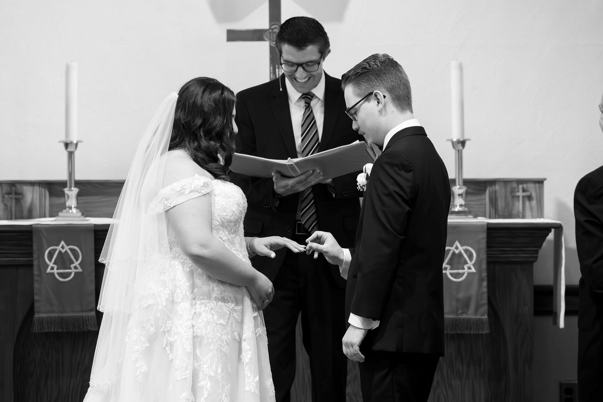 The bride and groom exchange rings at the altar on their wedding day at Immanuel Lutheran Church in Macomb, MI. 