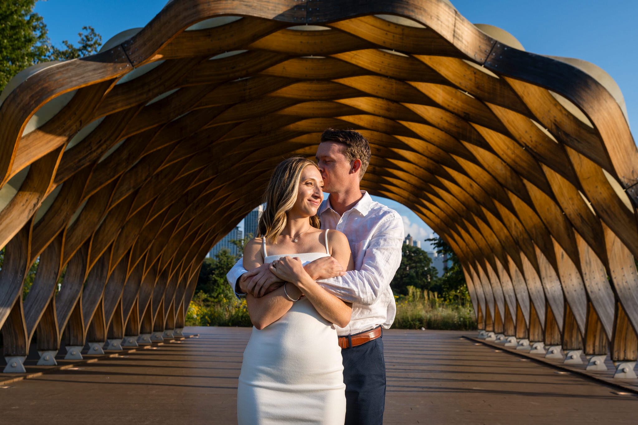 Inside a wooden structure at the Nature Boardwalk, a couple poses for their Lincoln Park Chicago engagement session. 