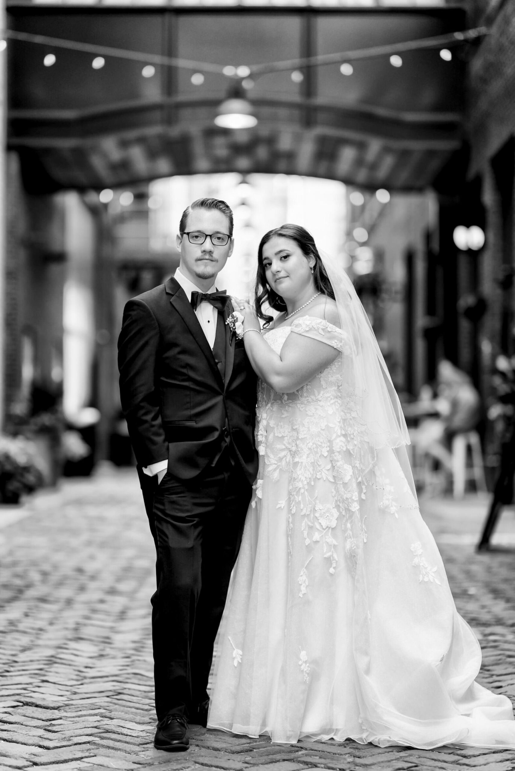 A bride and groom pose stoically on their wedding day in Parker's Alley.  