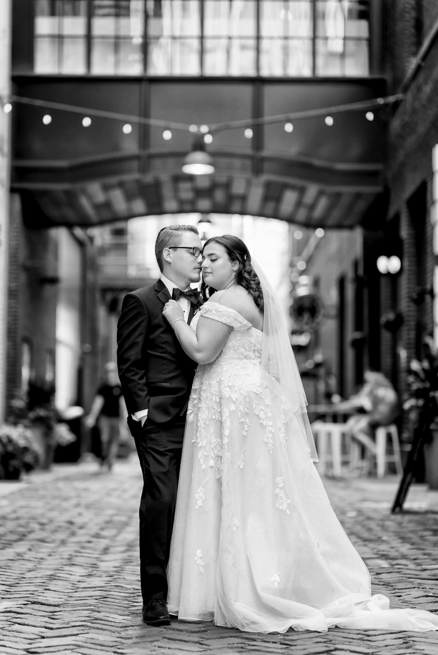 A couple poses and almosts kisses in Parker's Alley on their wedding day.  