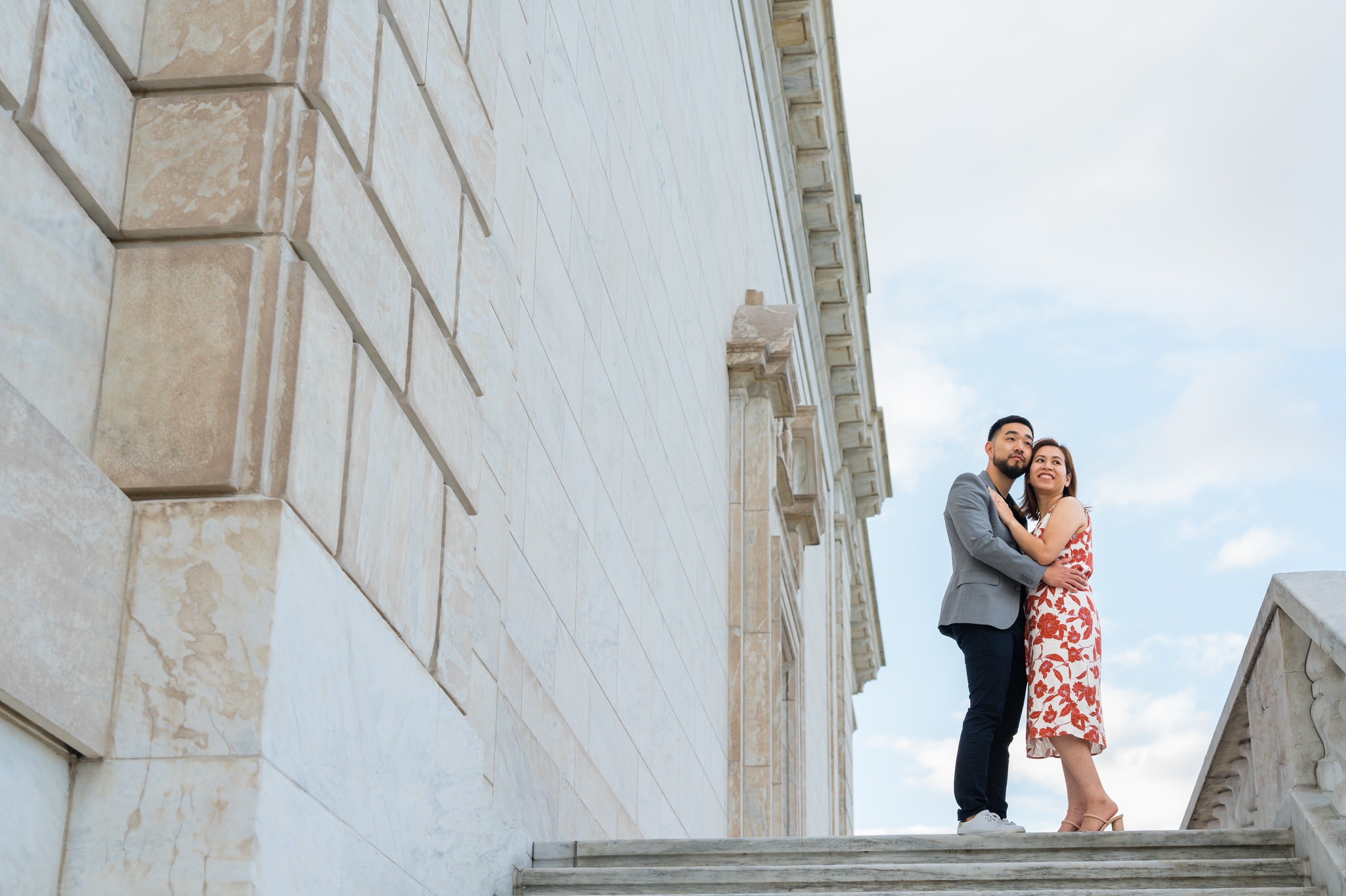 A couple stands atop the steps of the DIA during an engagement shoot.  