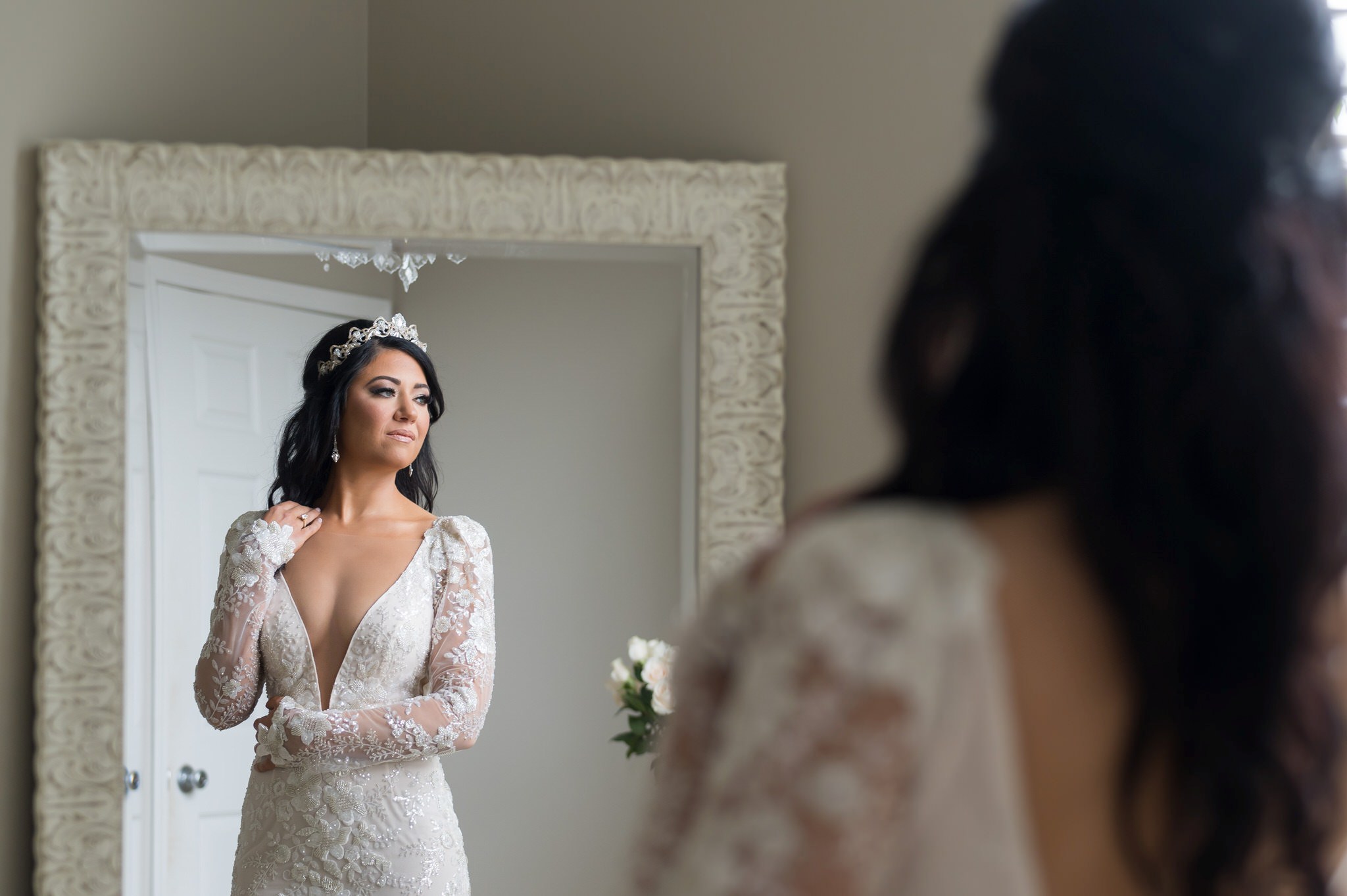 A reflection of a bride in a mirror as she looks outside on her wedding day.  