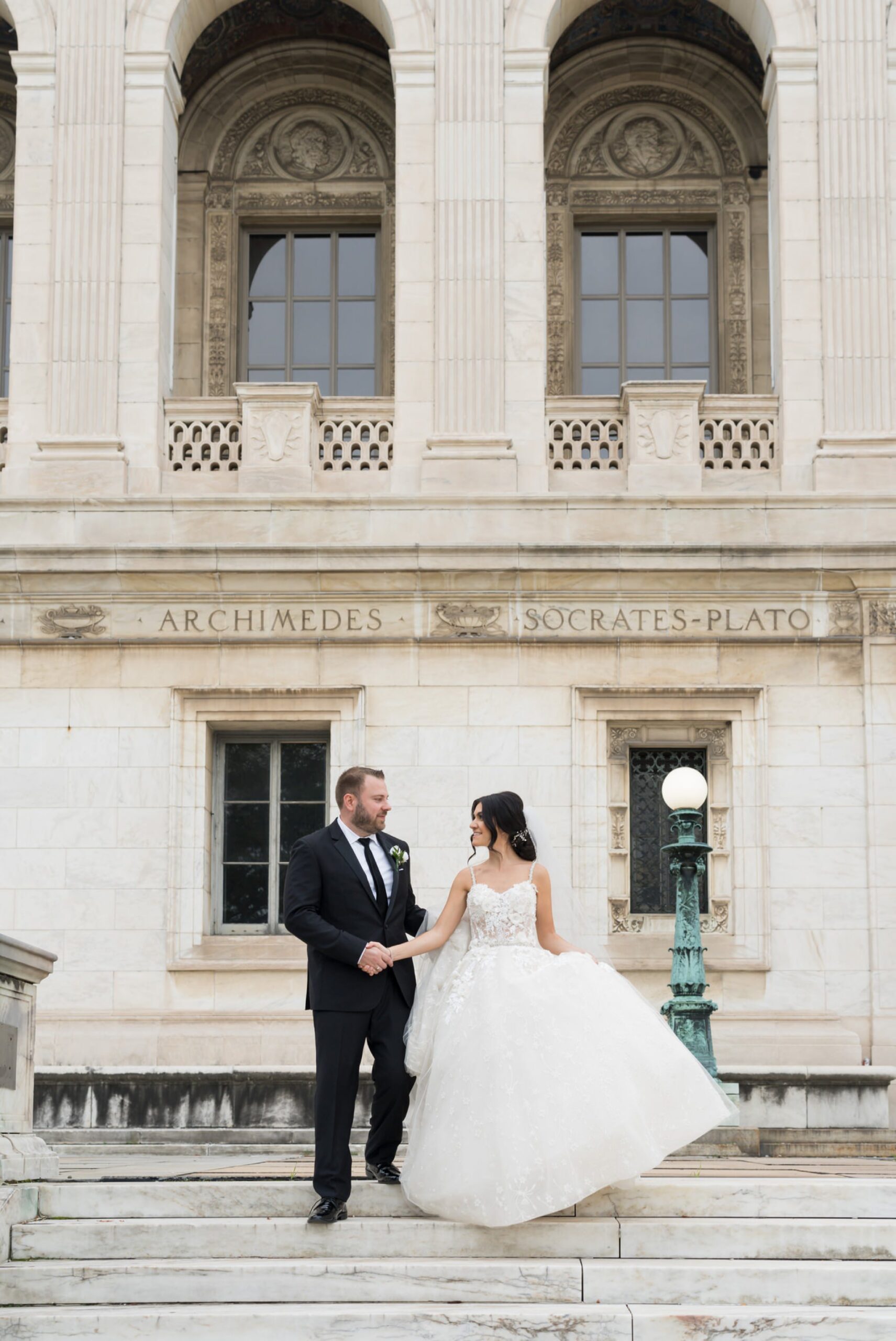 A bride and groom walk down the steps of the Detroit Public Library on Woodward.  