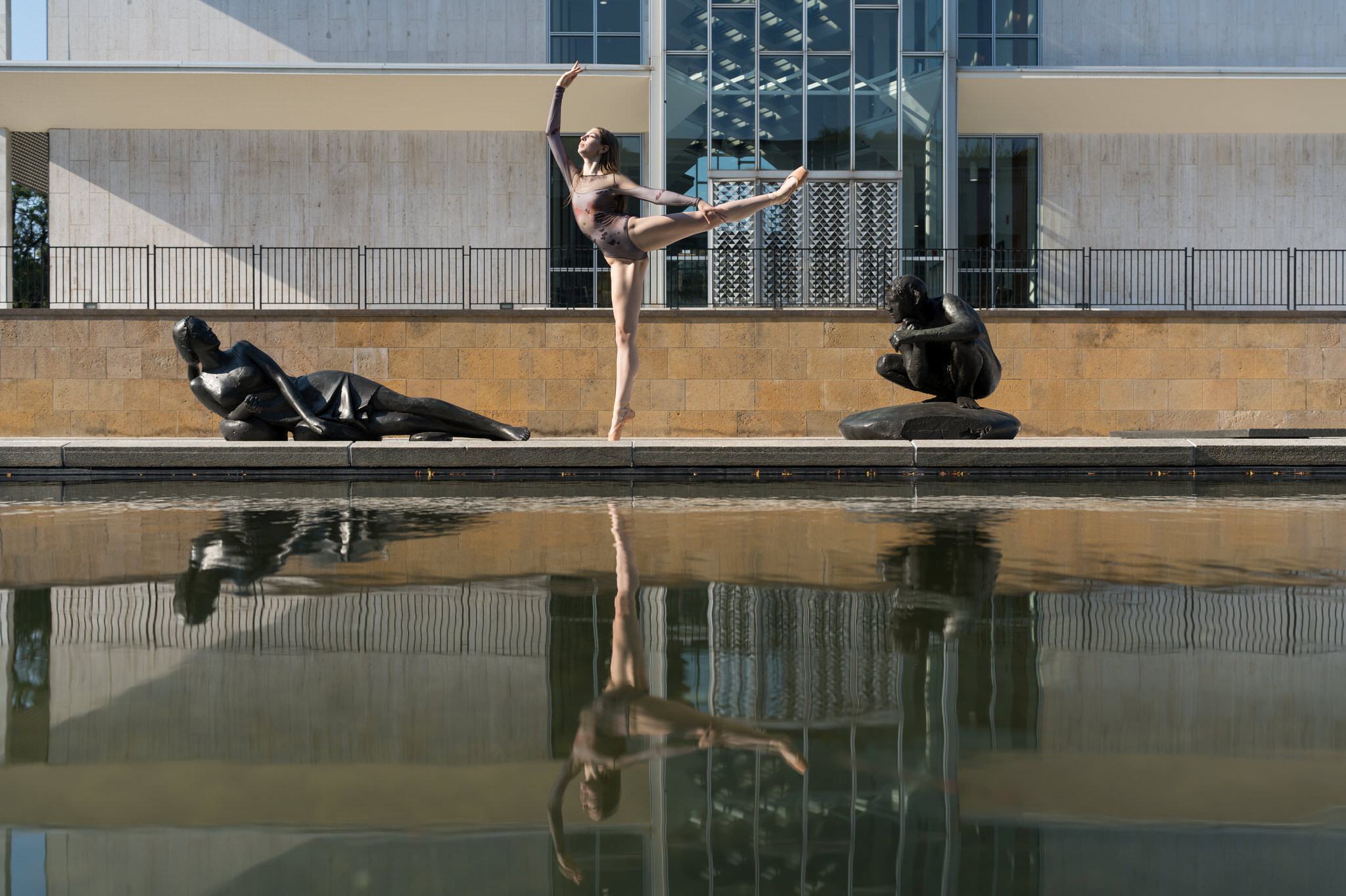 A dancer wearing a leotard poses on Wayne State University's campus for her Detroit senior pictures.  