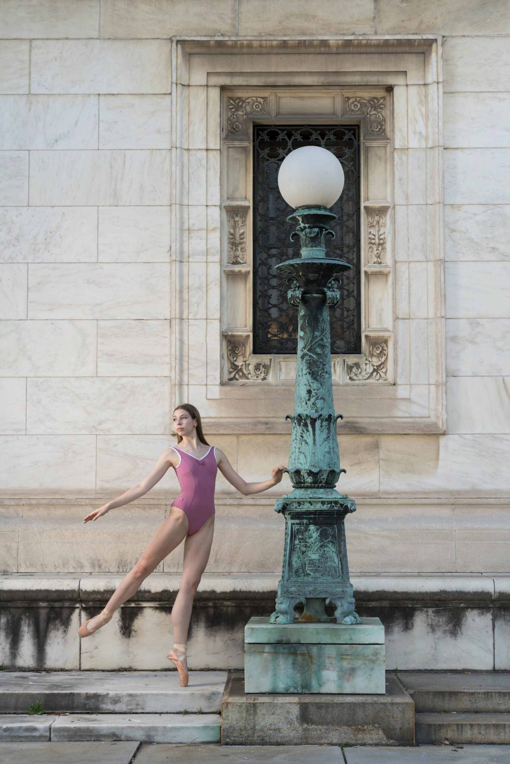 A dancer wearing a pink leotard poses at the Detroit Public Library for her Detroit senior pictures.  