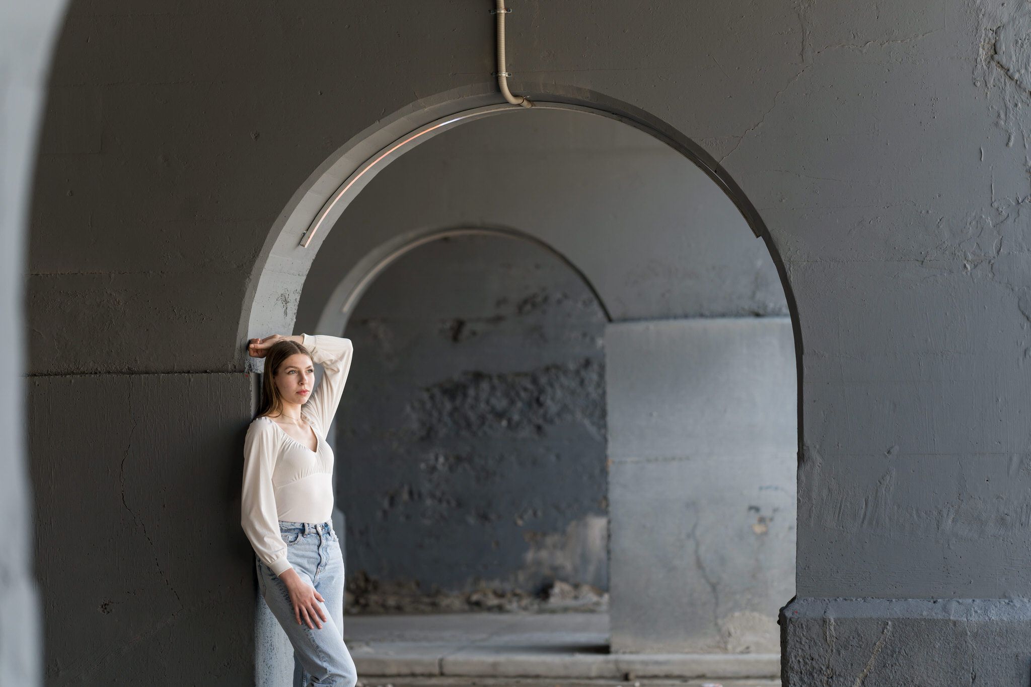 A teen poses for her Detroit senior pictures under an archway in Midtown.
