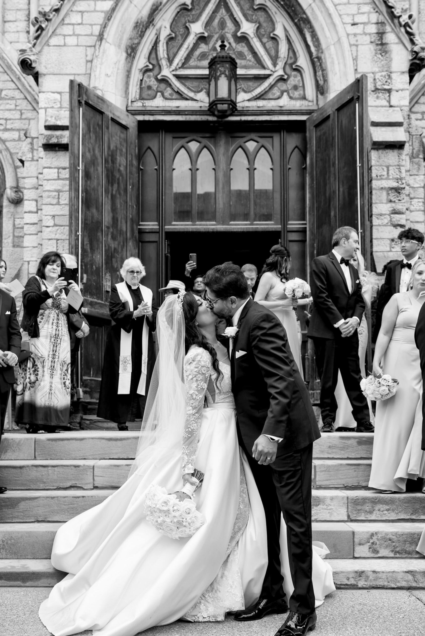 A bride and groom celebrate on the steps after marrying at Fort Street Presbyterian Church Detroit wedding