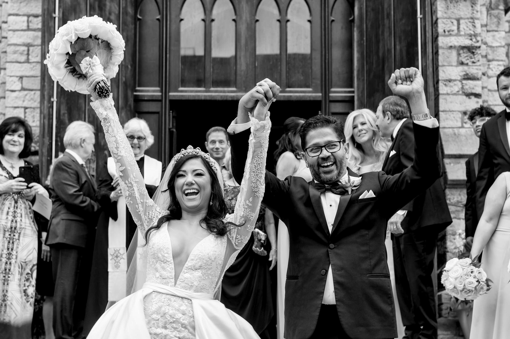 A bride and groom celebrate on the steps after marrying at Fort Street Presbyterian Church Detroit wedding