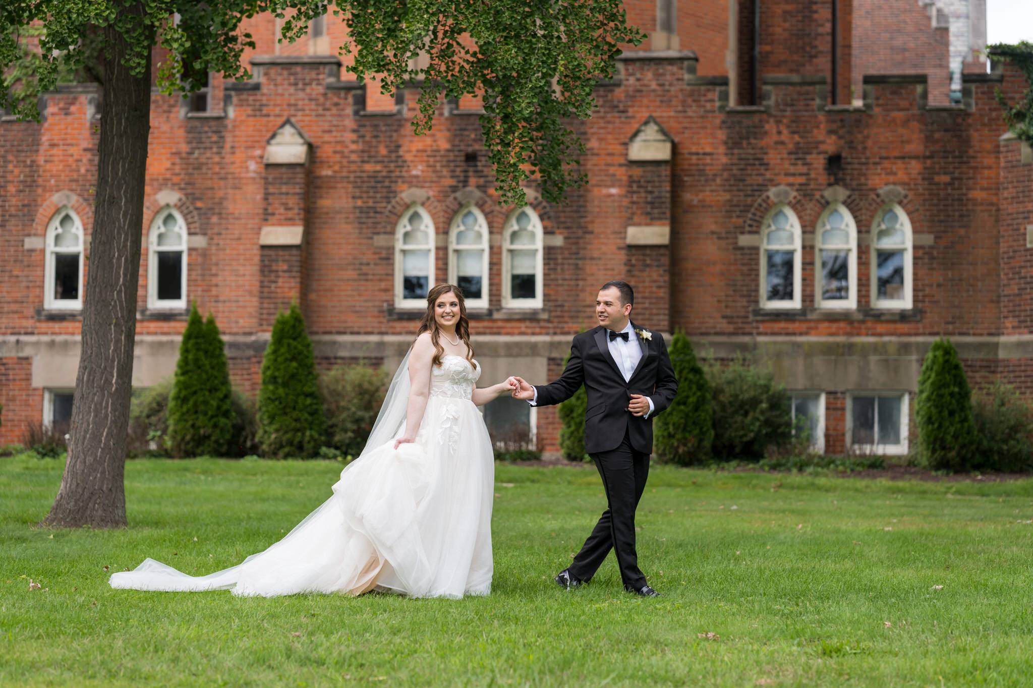 A bride and groom walk the grounds outside at their Grosse Pointe Academy wedding.  