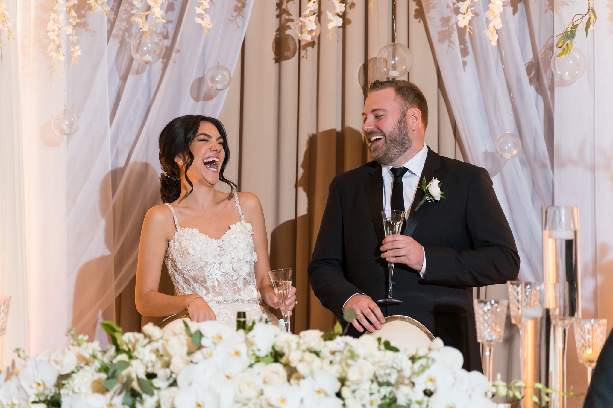 A bride and groom laugh during wedding toasts at Palazzo Grande in Shelby Township, MI.  