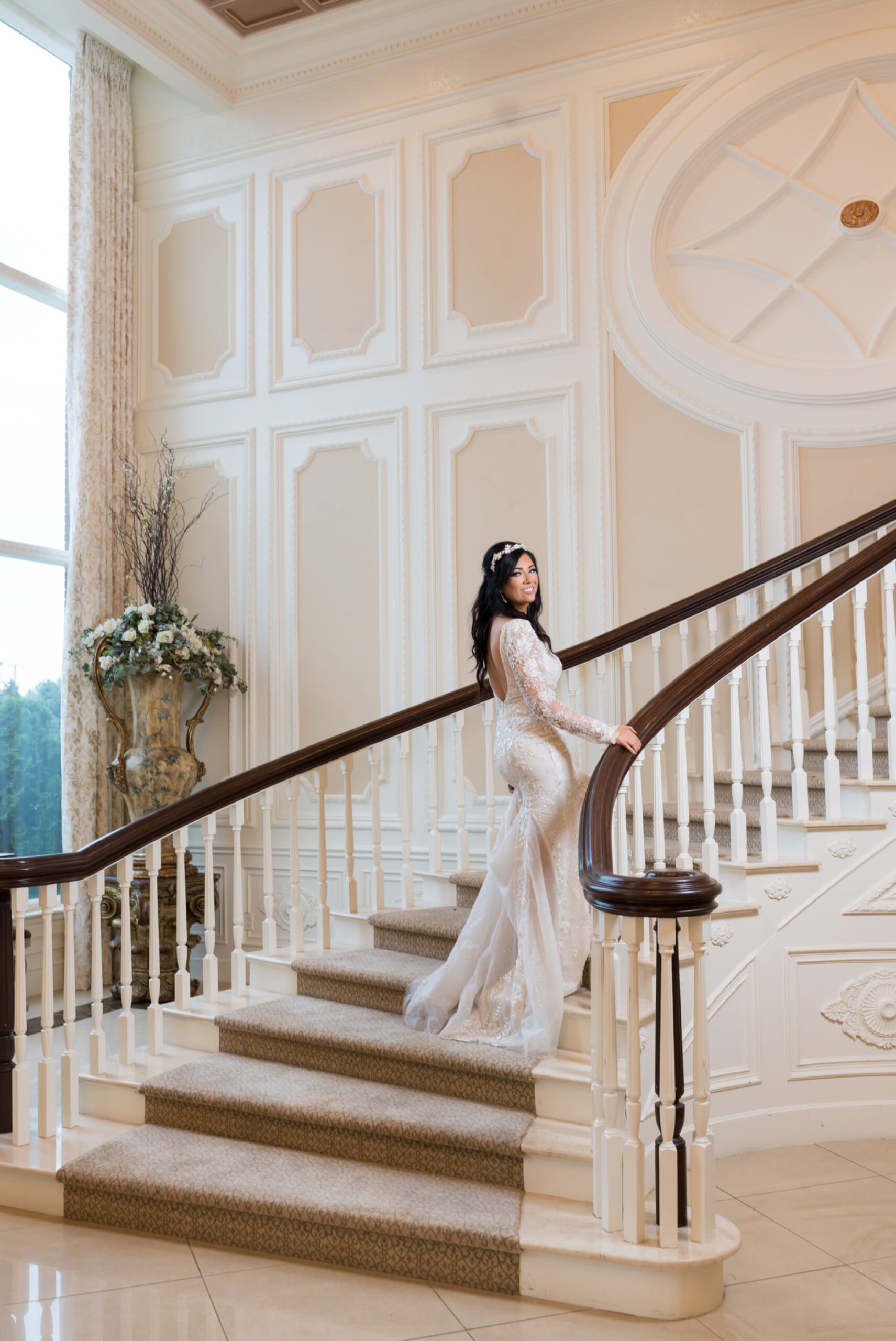 A bride poses on a long staircase at a wedding reception at Penna's of Sterling. 
