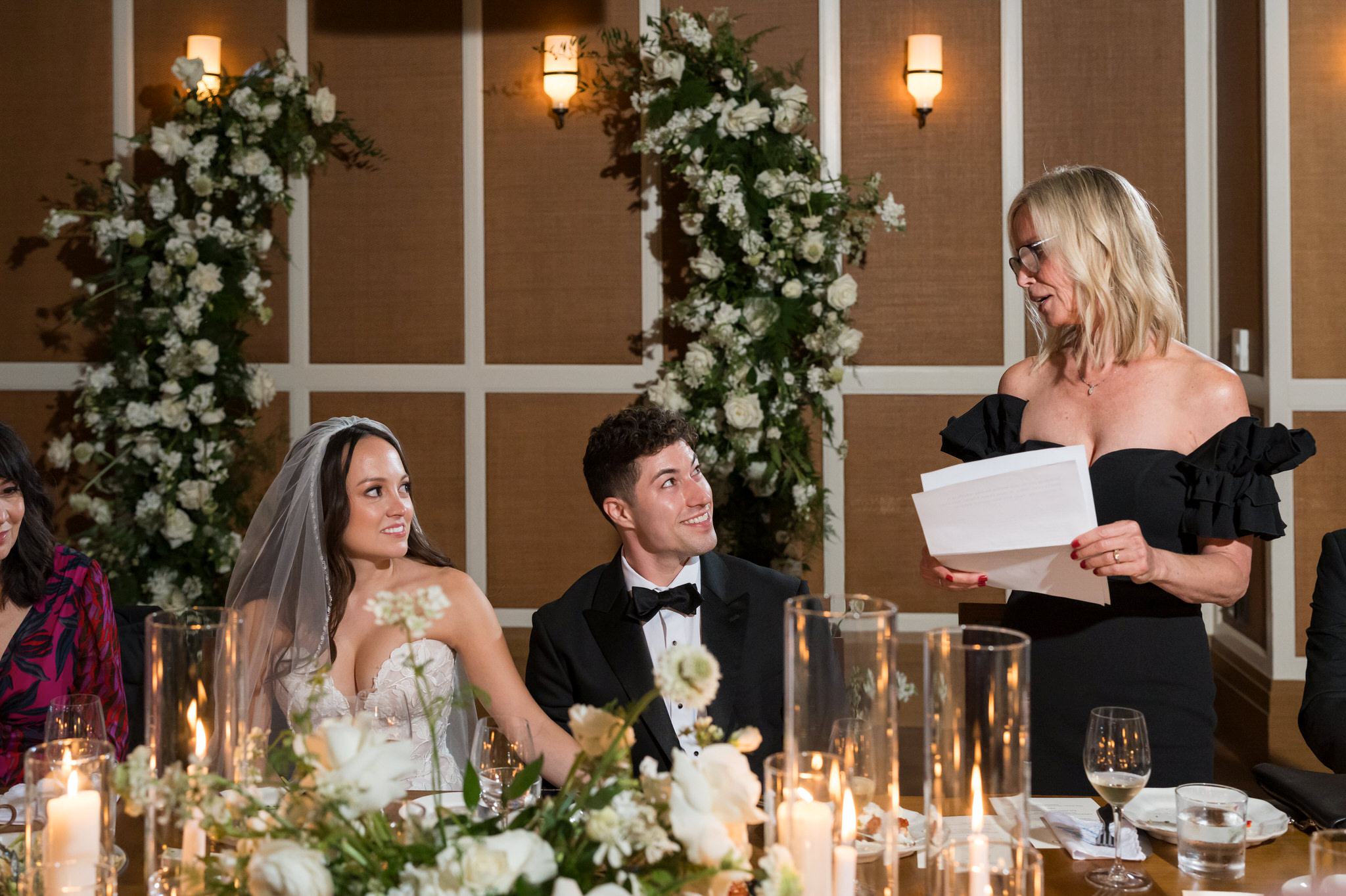 A bride and groom look towards a mom during a toast at a San Morello wedding. 
