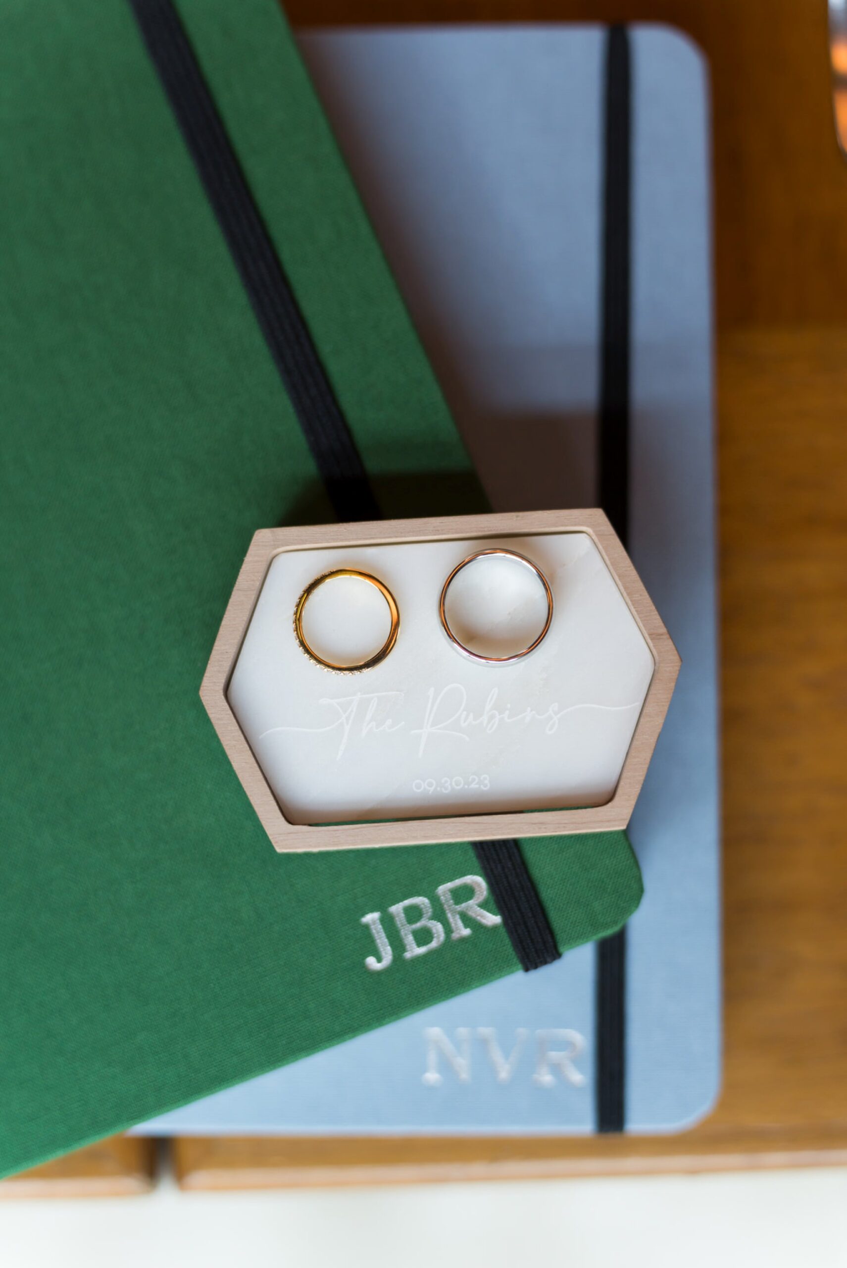 Wedding rings sit on top of monogramed Shinola journals.  