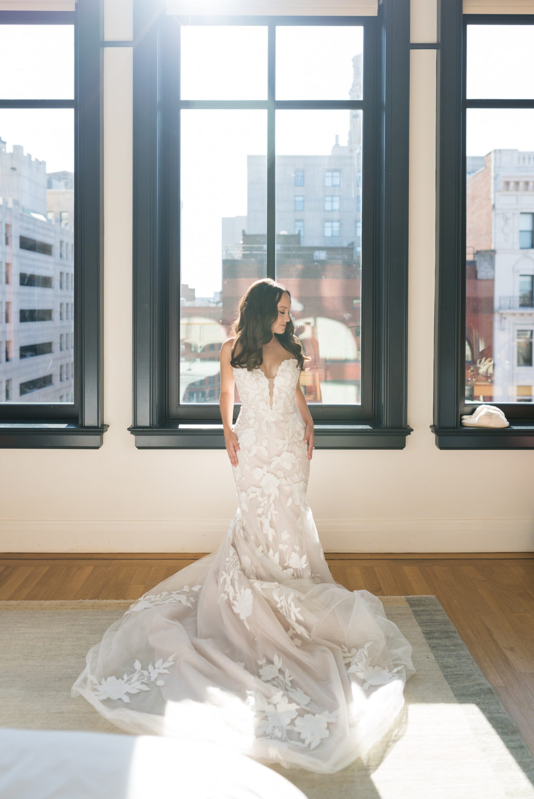 A bride poses in front of a window at the Shinola Hotel before her San Morello wedding later that day.   