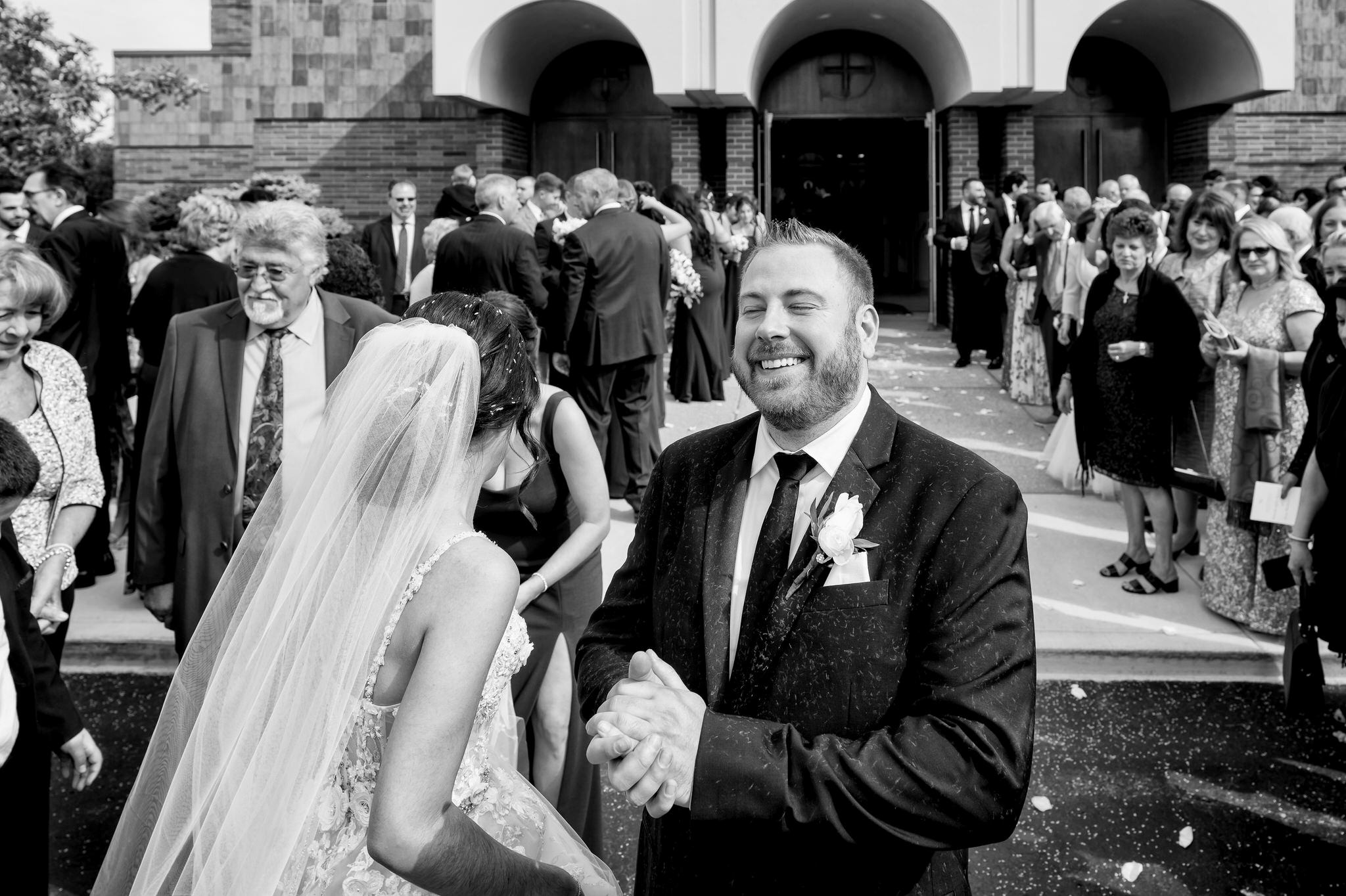 A groom smiles after rice is thrown on him during the ceremony exit from his Assumption Greek Orthodox wedding in St. Clair Shores, Michigan. 