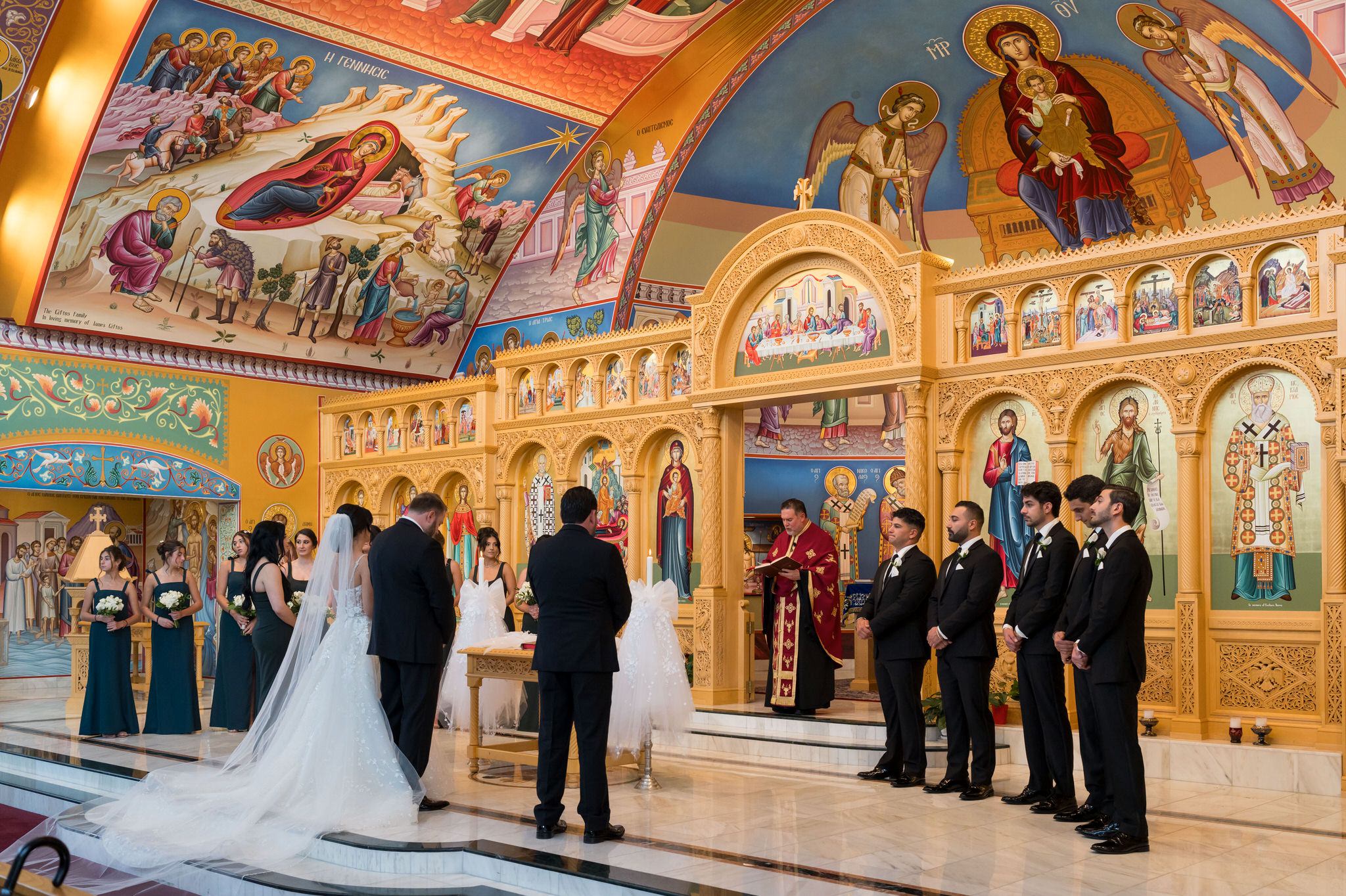 A wedding party stands at the altar of a Assumption Greek Orthodox wedding in St. Clair Shores, Michigan.