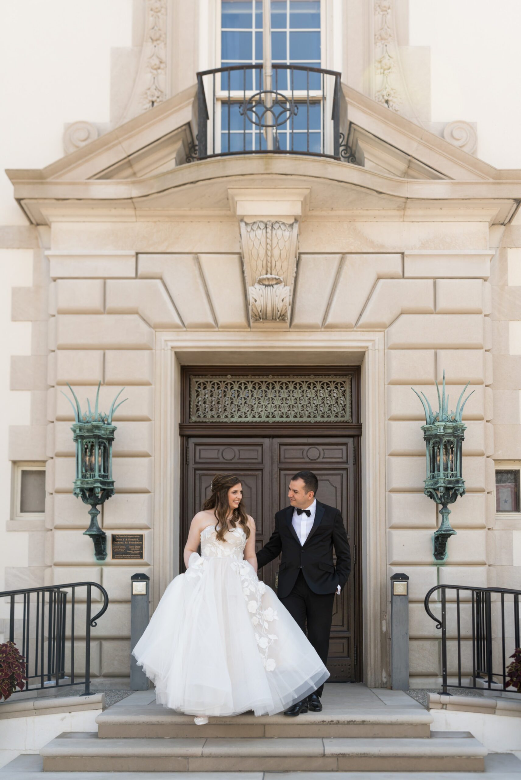 A bride and groom walk down the steps on their wedding day at The War Memorial in Grosse Pointe Farms.